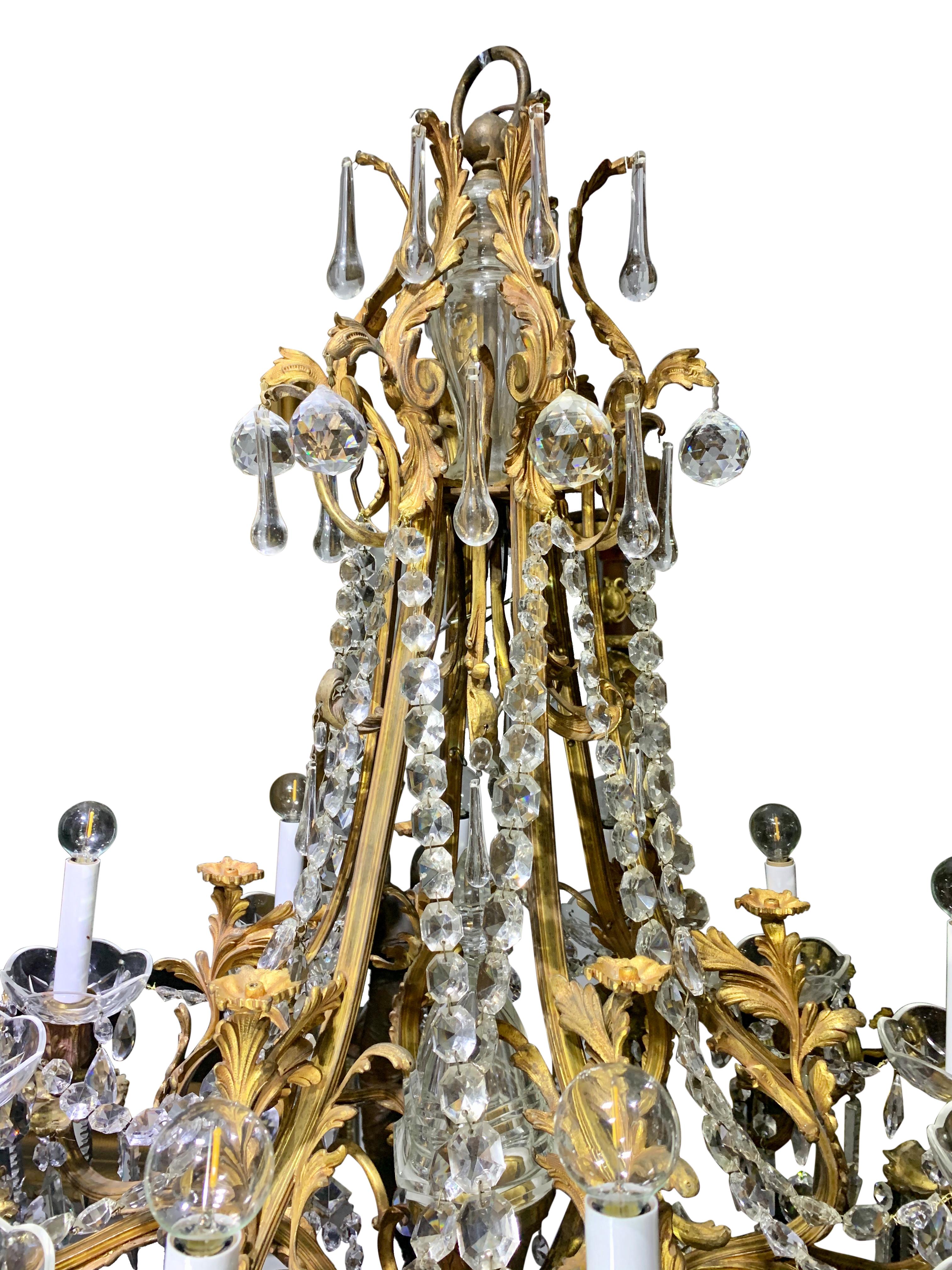 Exceptional 19th century French Louis XVI Marie Antoinette style gilt bronze mounted crystal 12 light chandelier. The chandelier is centered by a beautiful solid cut crystal ball pendant amidst lovely cut crystal pendants and crystal chains. The
