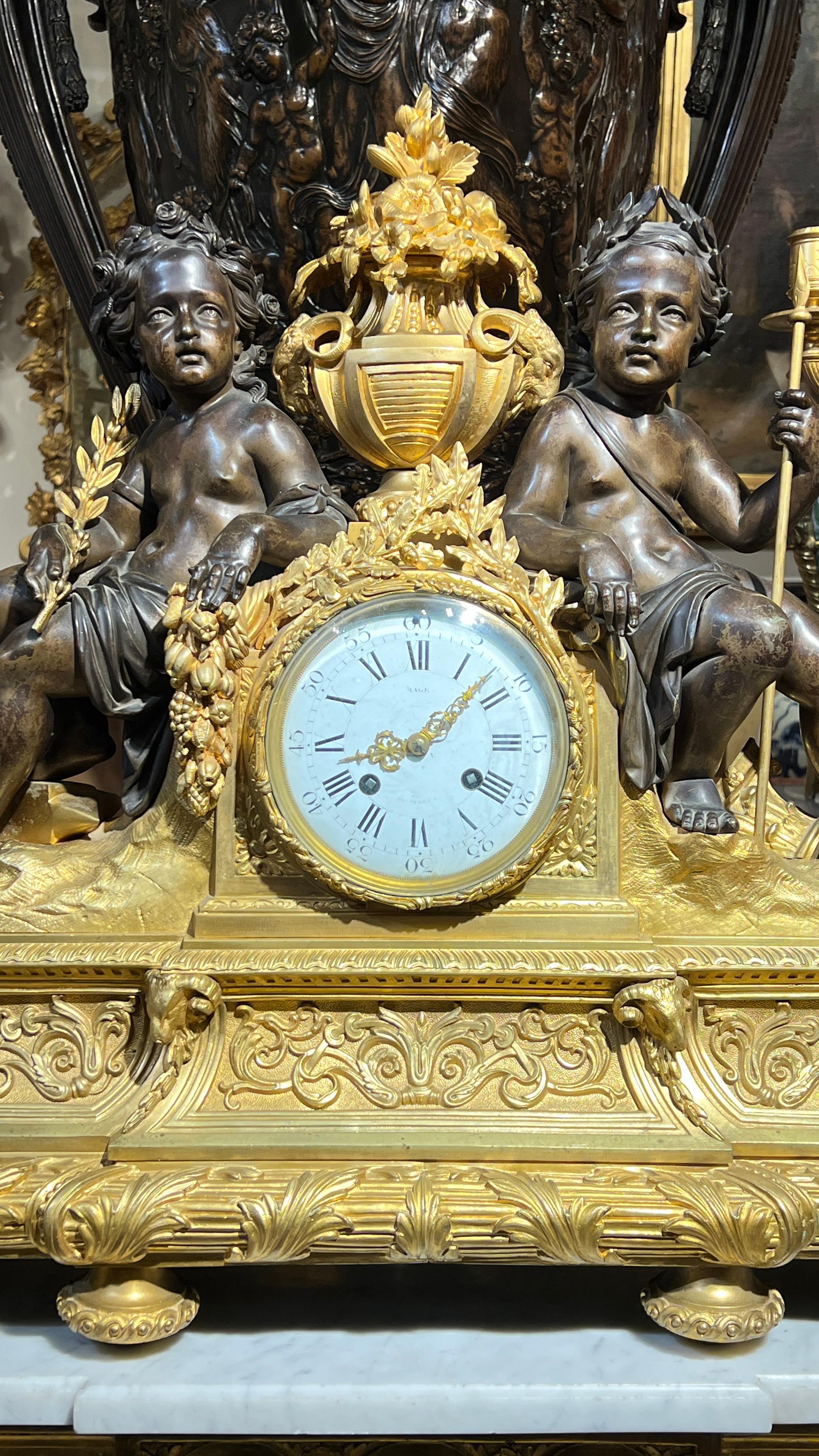 Magnificent antique (late 19th century) ormolu bronze garniture set in the Louis XVI style, including mantel clock with patinated seated putti and pair of candelabra.  Clock made by Villard of Paris.  Clock 24 1/2 by 29 1/2 by 8 1/2 inches. 