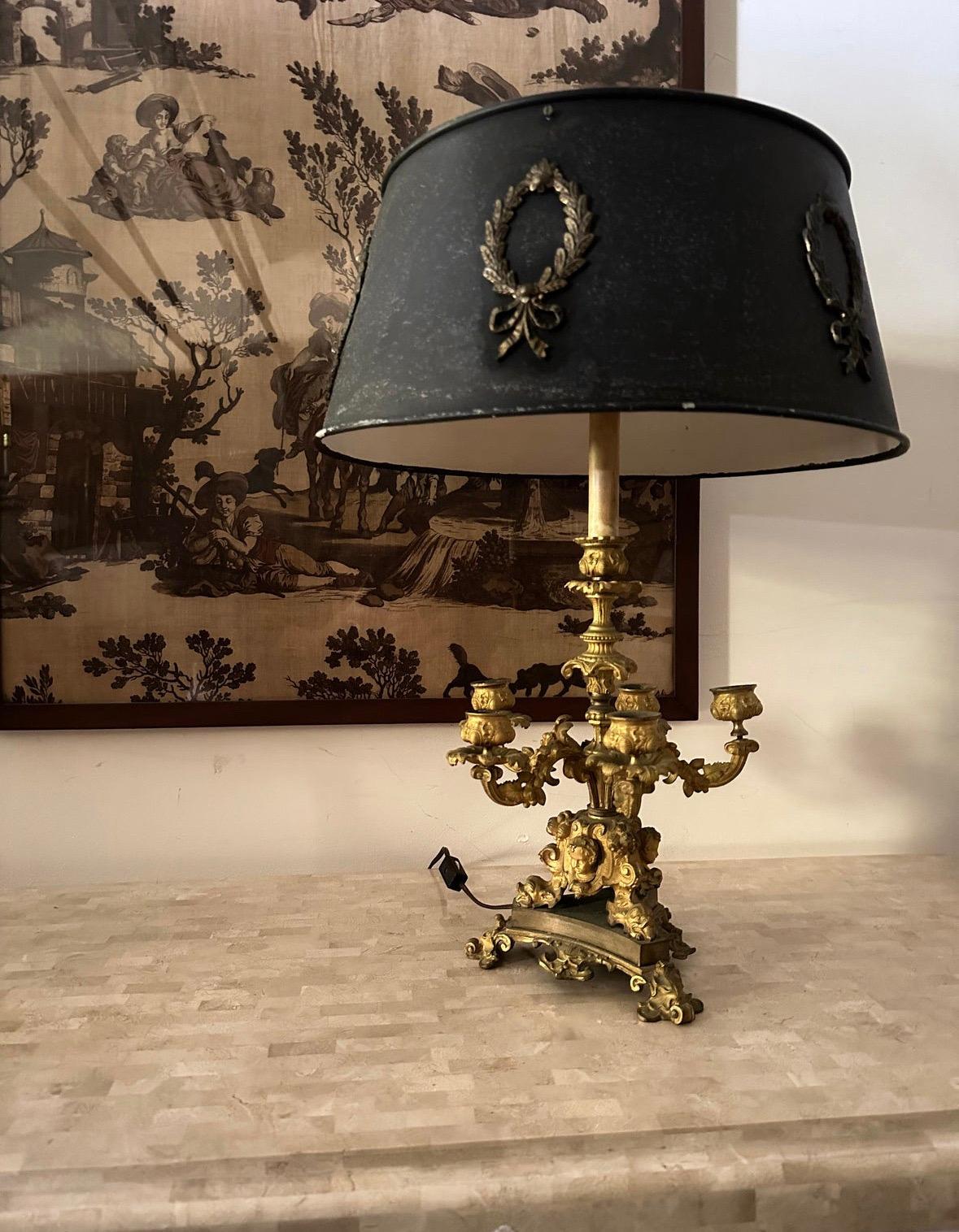 Exceptional casting. Truly stunning 19th century French candelabra converted to lamp with a great tole shade.


Tole shade is showing paint losses but free from dings or damage otherwise.


Candle stick is missing a detail under one cup but is hard