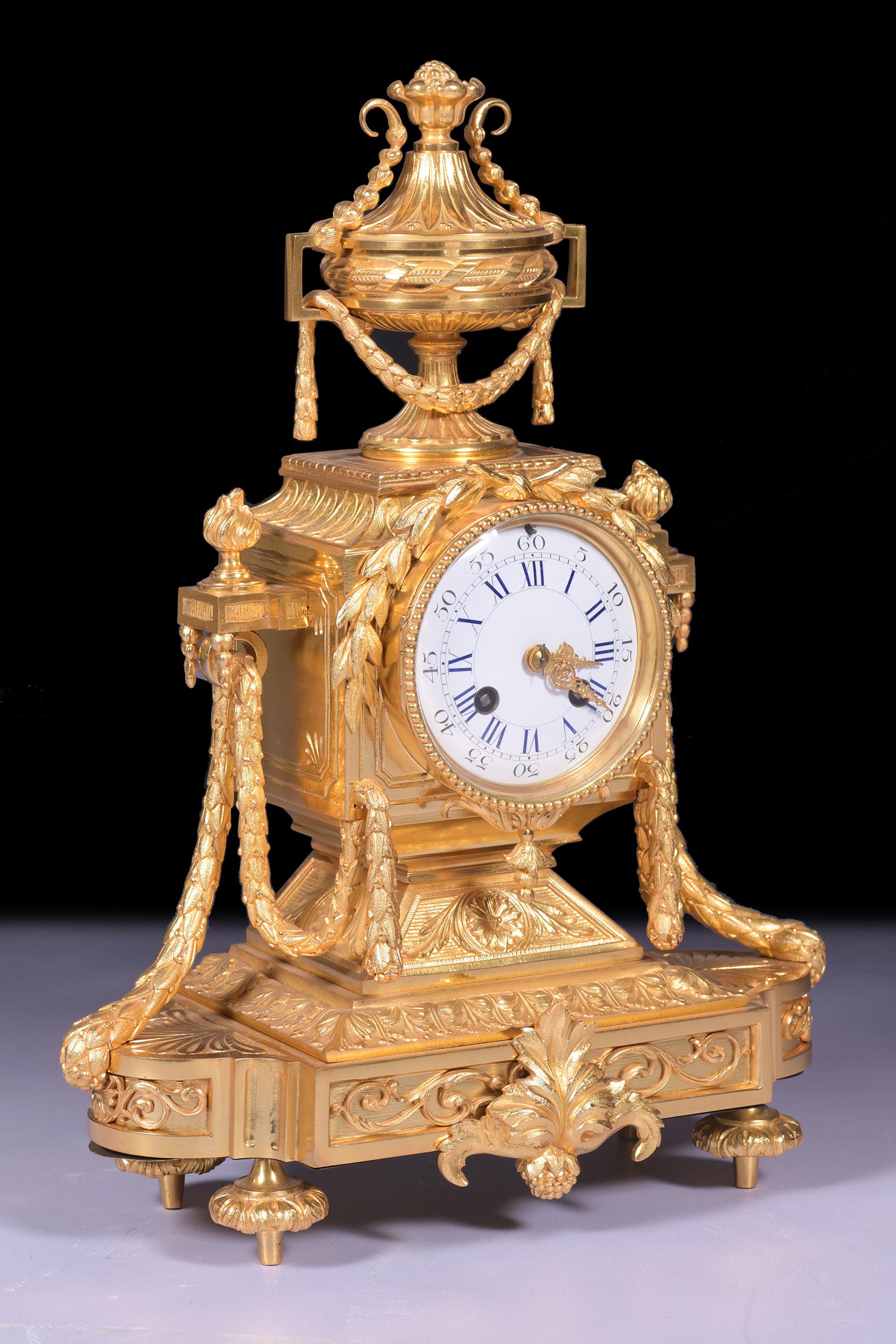 An exceptional quality 19th century Fench ormolu mantle clock in the Neoclassical style. The clock features a circular white enamel dial, which is inscribed with both Roman Numerals and Arabic Numbers. The dial is contained within a gilt bronze