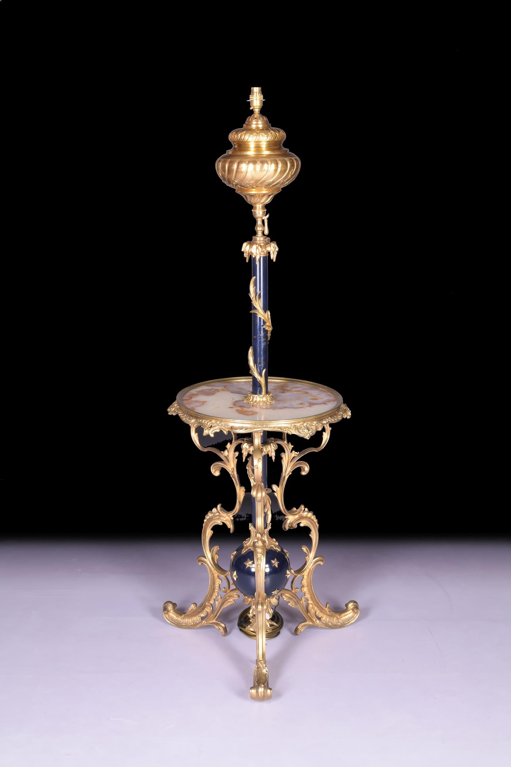 An exceptional quality Roccoco revival late 19th century French Ormolu and onyx telescopic standard lamp, having turned central column, to the circular vined marble shelf. All raised up on three ornate ormolu splayed supports terminating in pad