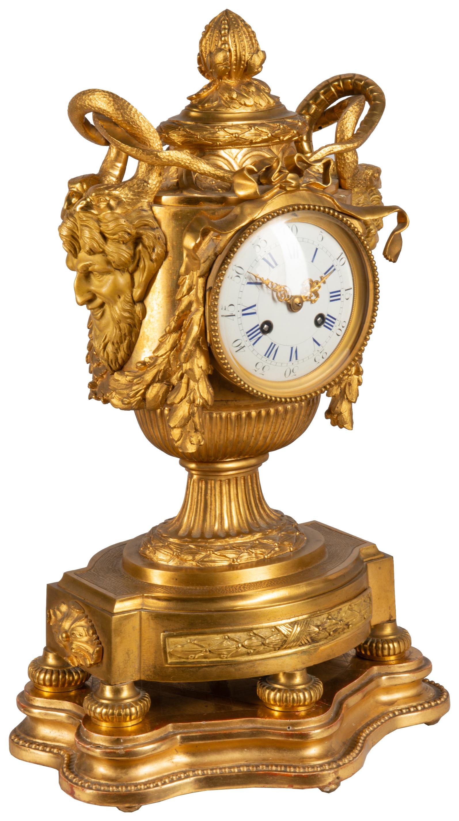 A very impressive 19th century French gilded ormolu Medusa influenced urn mantel clock. Having bearded masks to either side with serpents above foliate swags around the white enamel clock face, the movement being of eight day duration, chiming on