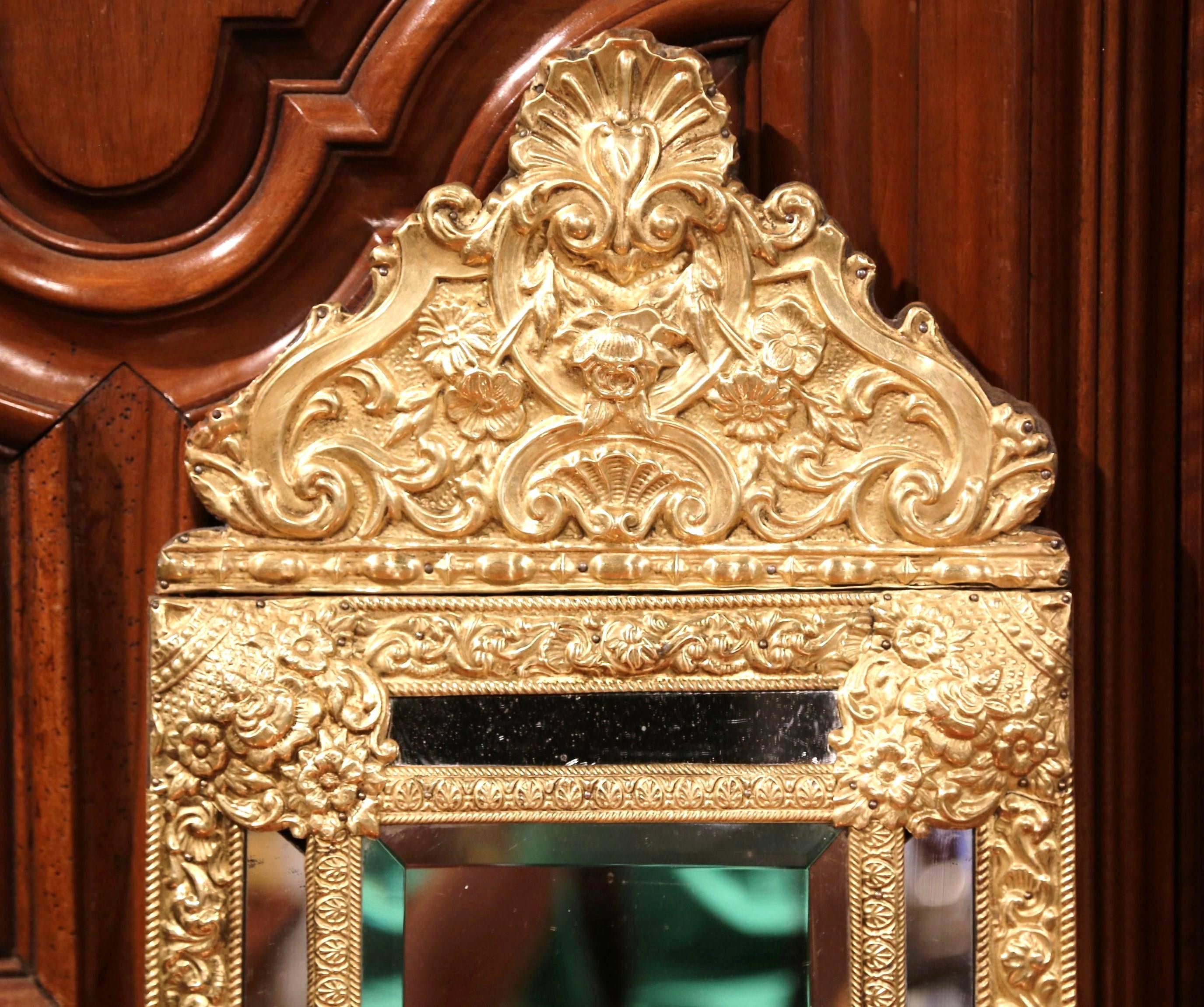 This small, elegant Napoleon III copper mirror was crafted in France, circa 1860. The antique wall hanging repousse piece features an ornate, heavily embellished pediment with a large carved shell and other decorative motifs. The central rectangular
