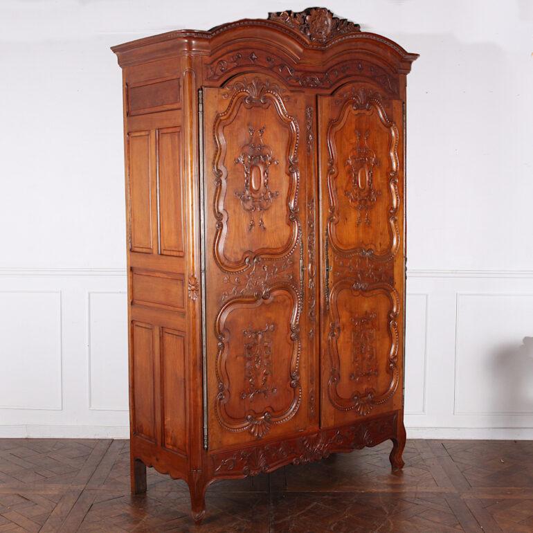 Large and impressive 19th century French Louis XV style double dome-top two-door armoire with profusely carved paneled doors and finely carved details throughout. Original heavy steel hinges and massive engraved escutcheons. Beautiful colour and