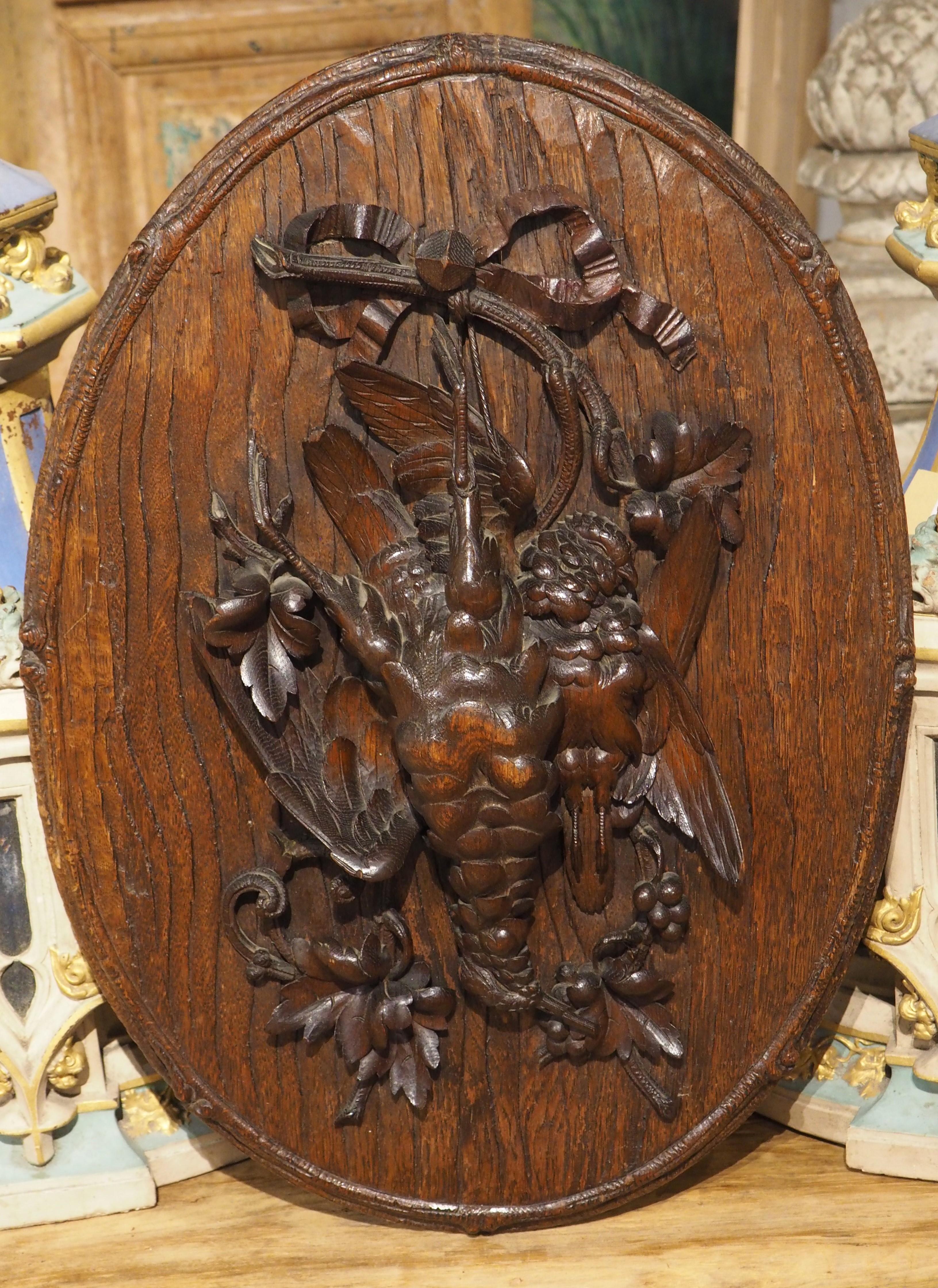 Hand-carved in France during the 1800s, this oval game plaque has amazing detail that includes a textured bark trompe l’oeil ground. Trompe l’oeil is a technique (loosely meaning “deceive the eye”) where the artist can render a three-dimensional