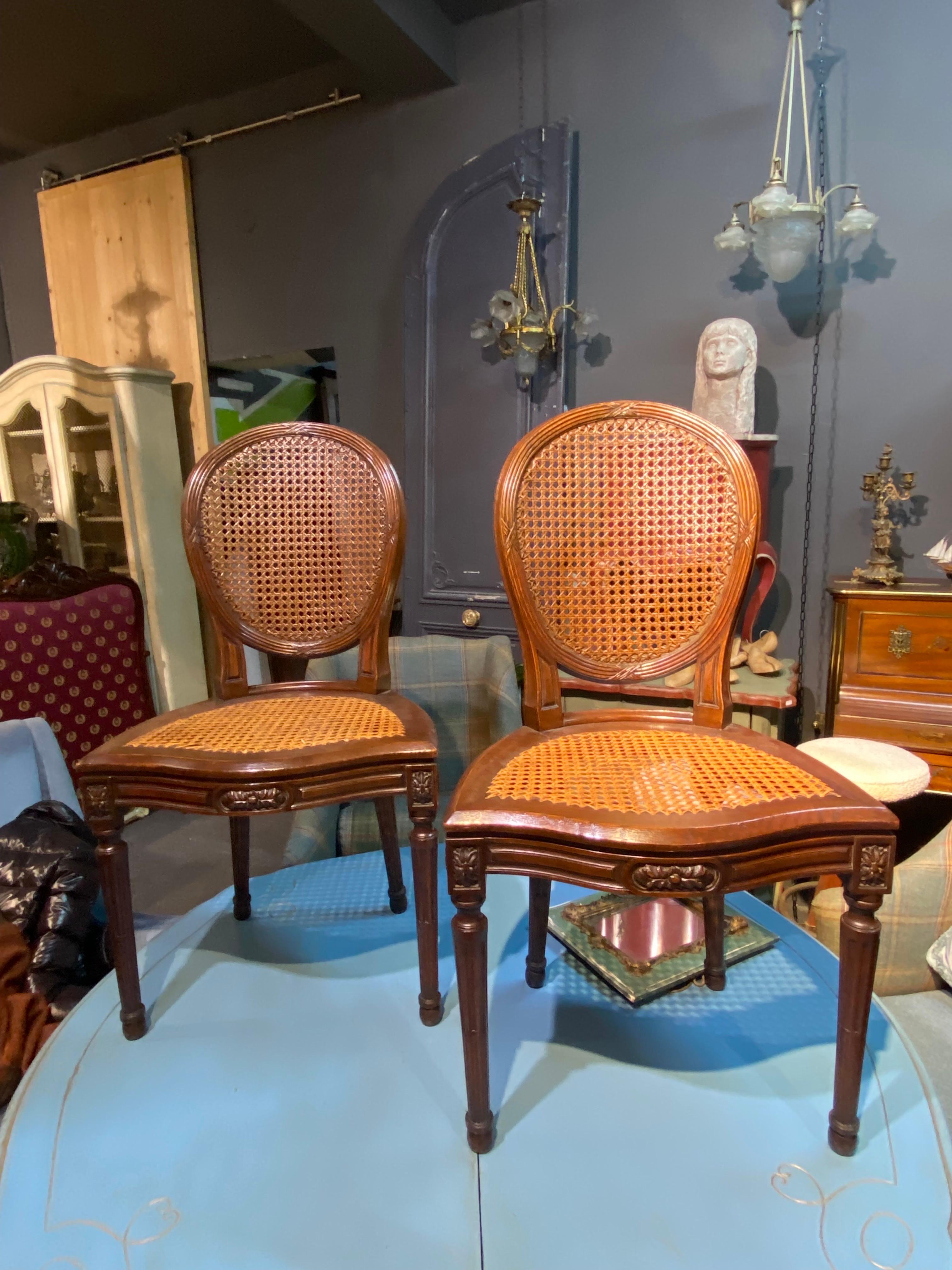 Six 19th century French carved walnut dining chairs in Louis XVI style, with hand-caned seats and backs. The chairs are raised on elegantly carved legs. All six are very stable as construction and the cane is in very good condition. Please note that