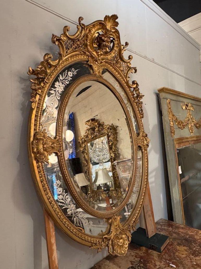 Ce produit est un miroir ovale Louis XVI stylisé du 19ème siècle français avec des panneaux latéraux gravés. Le miroir présente une forme ovale et des détails sculptés ornementaux, ajoutant une touche de...  l'élégance à n'importe quelle pièce. Les