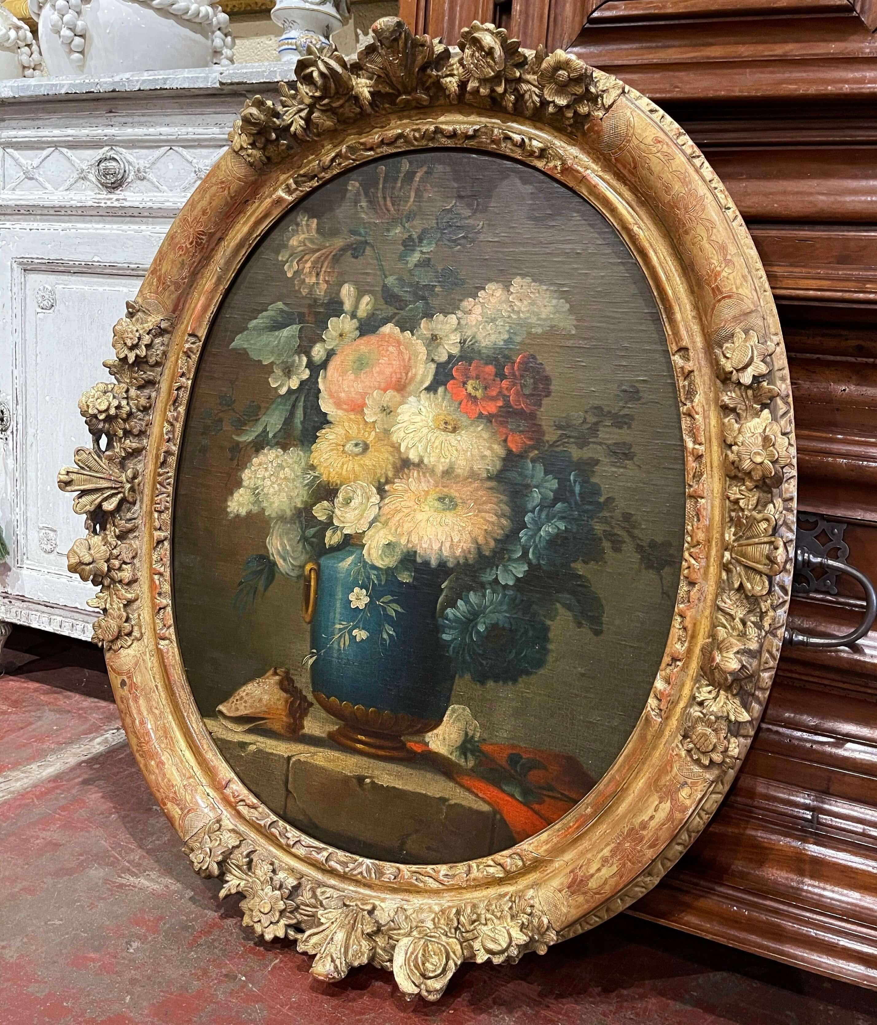 Invite color into your home with this antique oil on board painting. Painted in France circa 1870 and set in a carved gilt frame, the colorful composition features a cobalt blue vase dressed with bronze handle and base, and filled with a floral