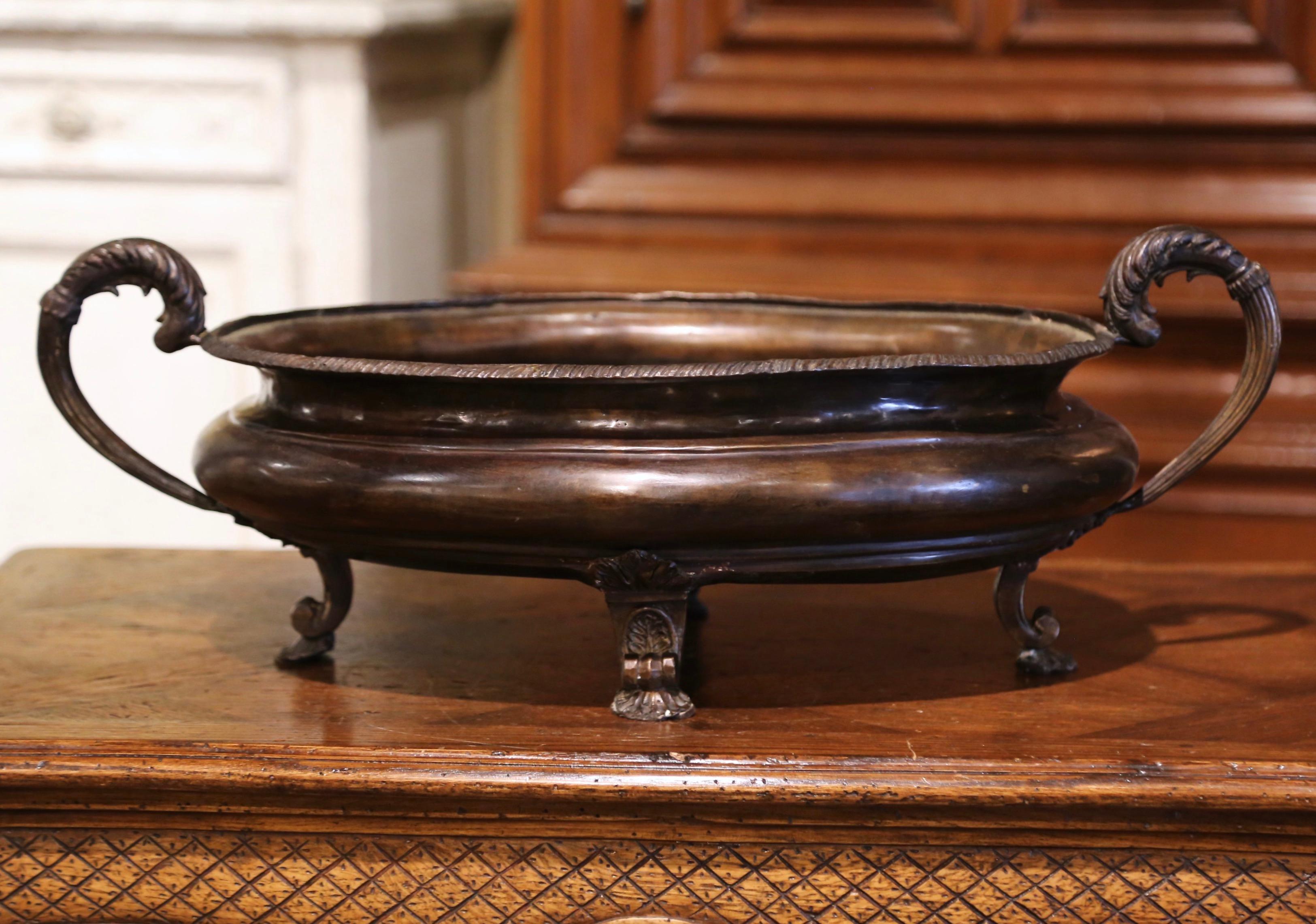 Decorate a dining table with this elegant antique planter. Crafted in France circa 1880, and made of bronze, the jardiniere stands on scrolled feet with foliate motifs. Oval in shape, the floral vase is dressed with leaf handles and features carved