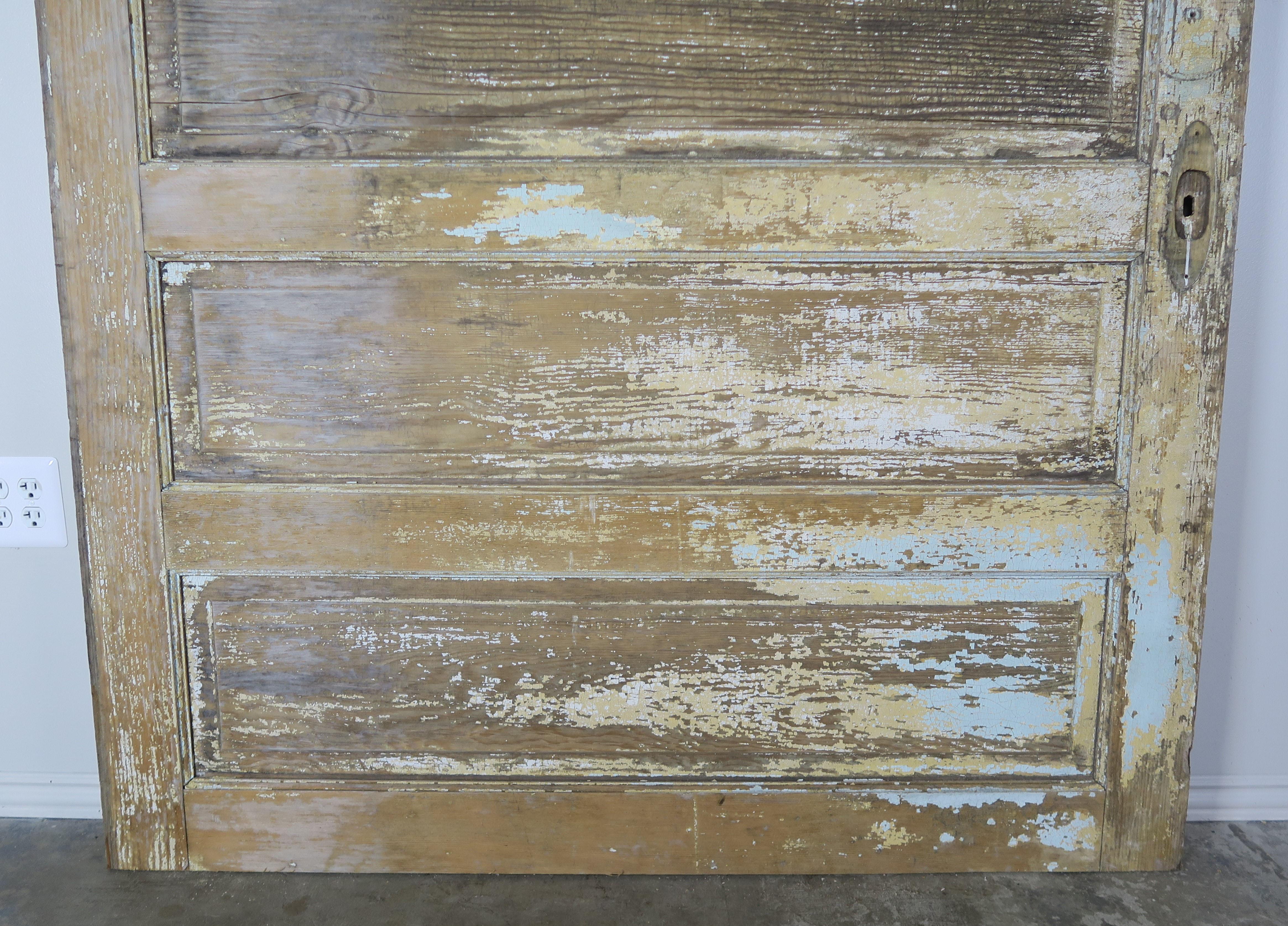 19th century French painted barn door with beautiful worn distressed finish. Cream, blue and remnants of ochre colored paint are seen throughout this fabulous door. It would make a great room divider that easily slides open to produce one large