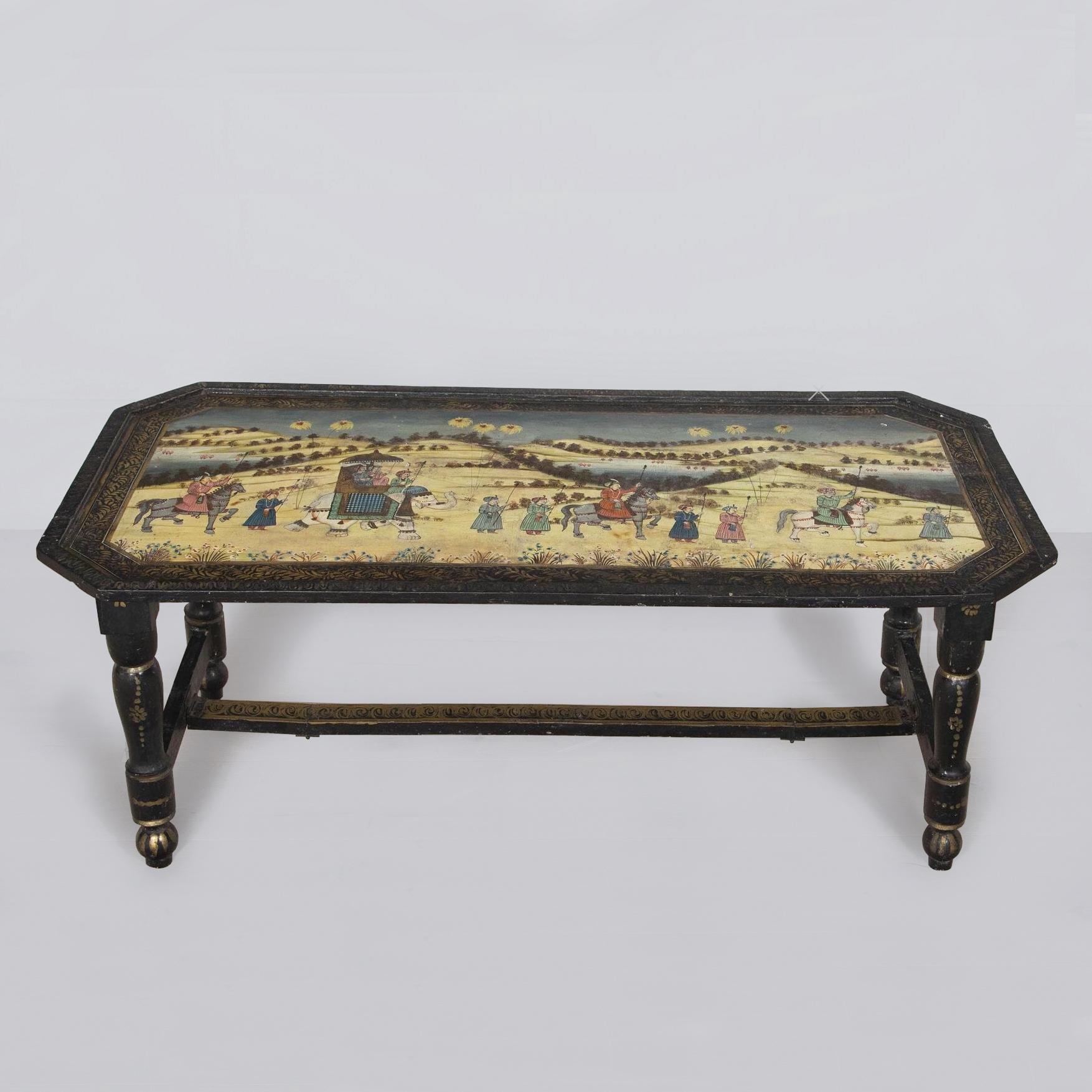 19th century highly unusual Napoleon III campaign low table decorated with a Mughal procession or festival with an elephant, horses and attendants travelling through a landscape of rolling hills.  The folding ebonised base with gilt decoration.