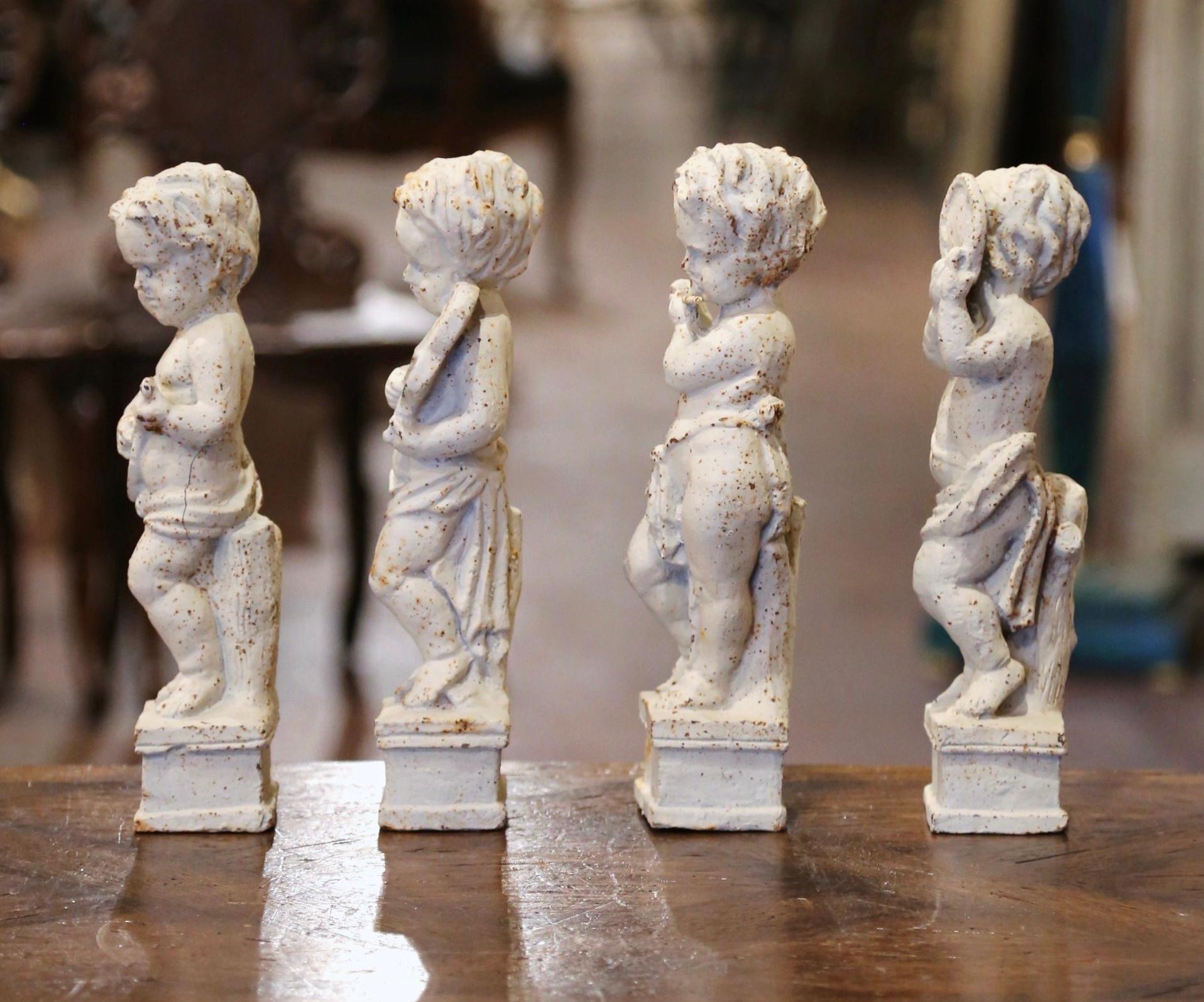 Decorate an office or study's shelf with this elegant suite of antique putti statues. Crafted in France circa 1870, and made of iron, each musical cherub stands on a rectangular base, and plays a different musical instrument; violin, flute, sitar