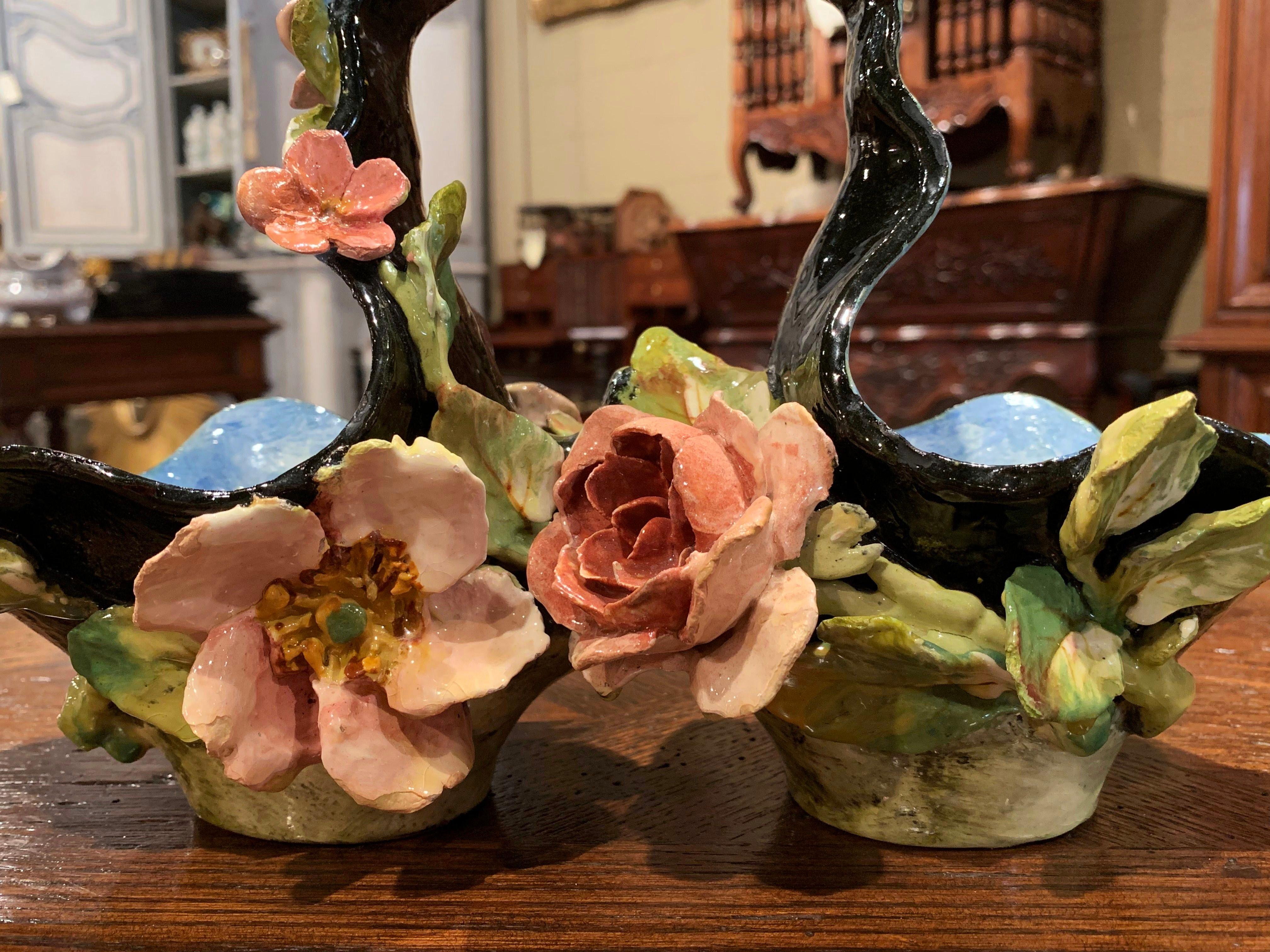 Place this sculptural, antique jardinière on a shelf or on a kitchen counter for a pop of color. Crafted in Montigny-sur-Loing, France circa 1860, the colorful basket has a central handle and features a double vase decorated with floral and leaf