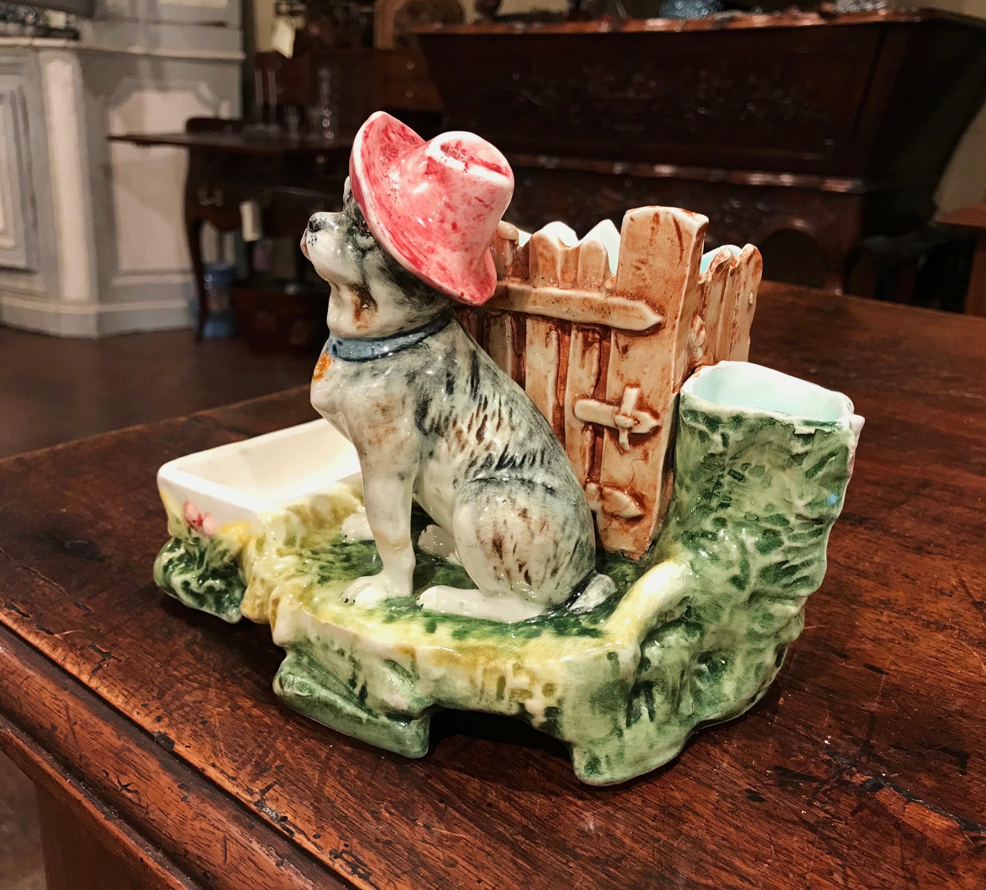 Animate your mantel (fireplace) or side table with this charming antique Majolica composition. Crafted in France circa 1890, the match safe sculpture features a bulldog wearing a hat with match and cigarette compartments on both side. The playful