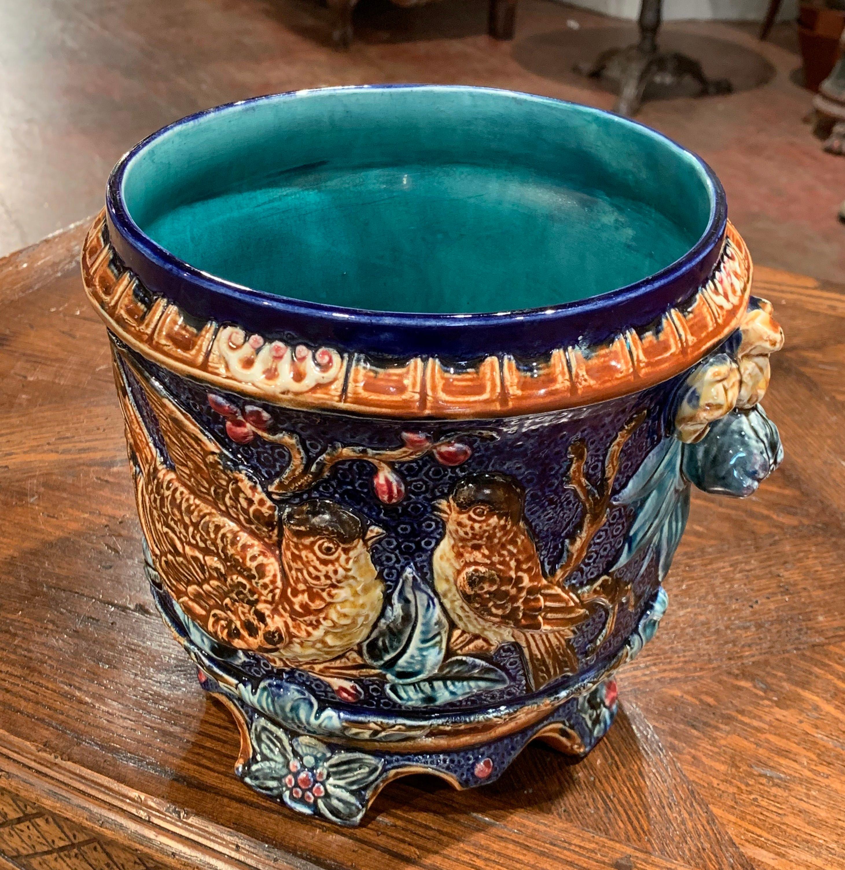 Decorate a table or a console with this colorful, antique Majolica planter. Created in France circa 1860, the sculptural ceramic cachepot with fruit side handles, sits on four scroll feet under a scalloped apron; the vase feature hand painted decor