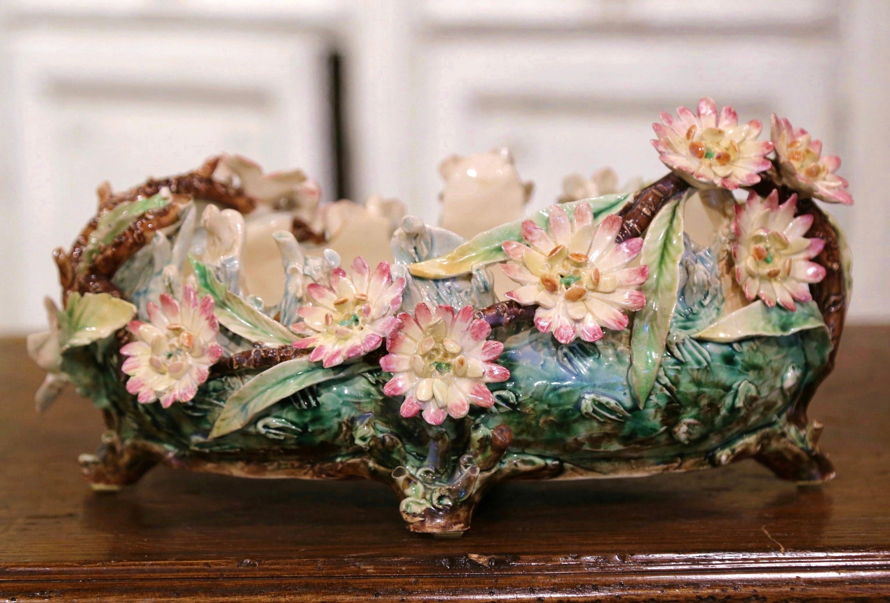 Décorez une table ou une console avec cette jardinière antique en majolique colorée. Créé en France vers 1880, ce cache-pot sculptural en céramique repose sur quatre pieds en forme de branches d'arbre. Le pot est décoré de fleurs de Marguerite