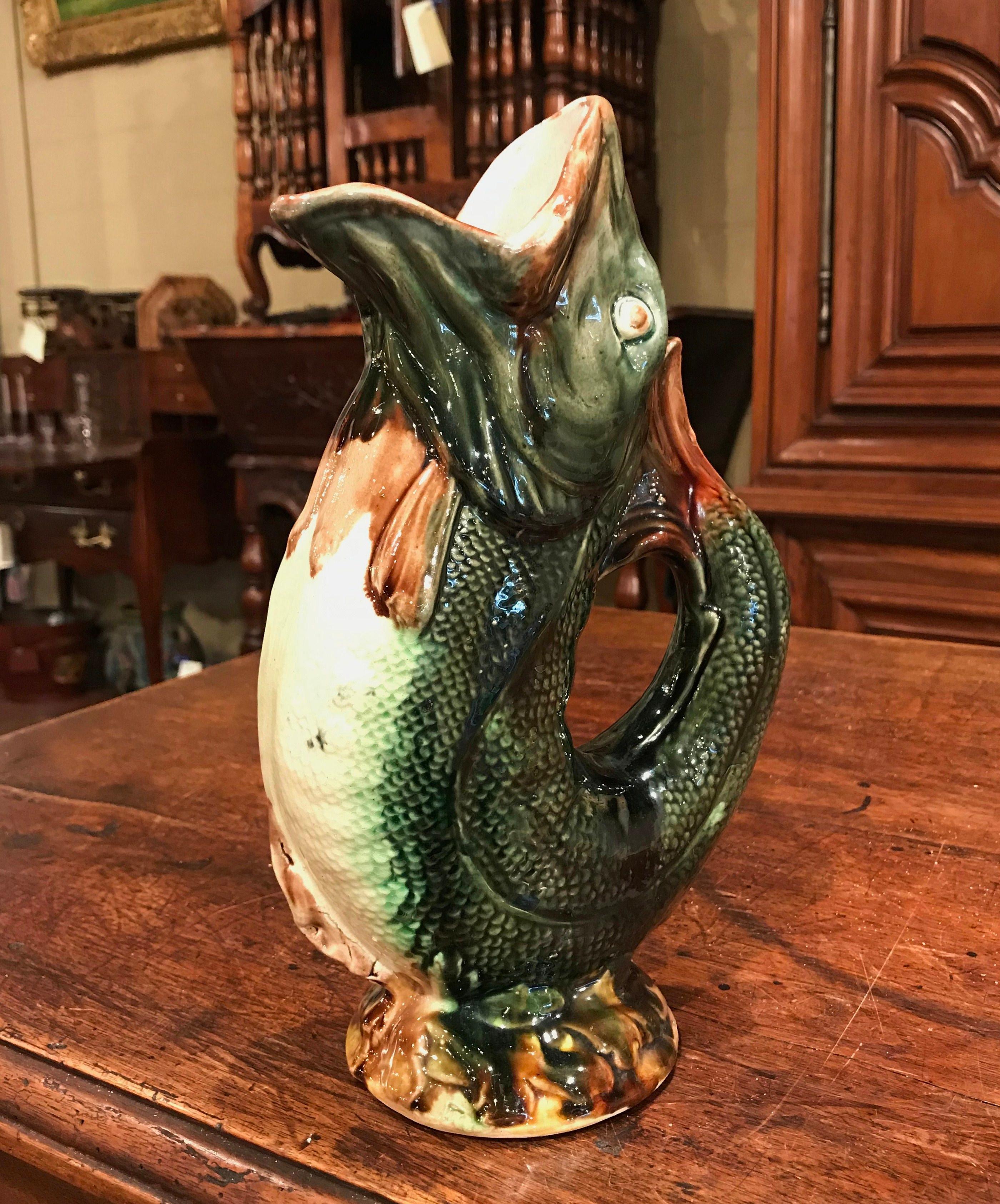 This lively pitcher would make an interesting addition to any porcelain collection. The colorful, antique water pitcher shows the beautiful artistry and painterly application of color true to Majolica ceramics. The porcelain vase was sculpted in