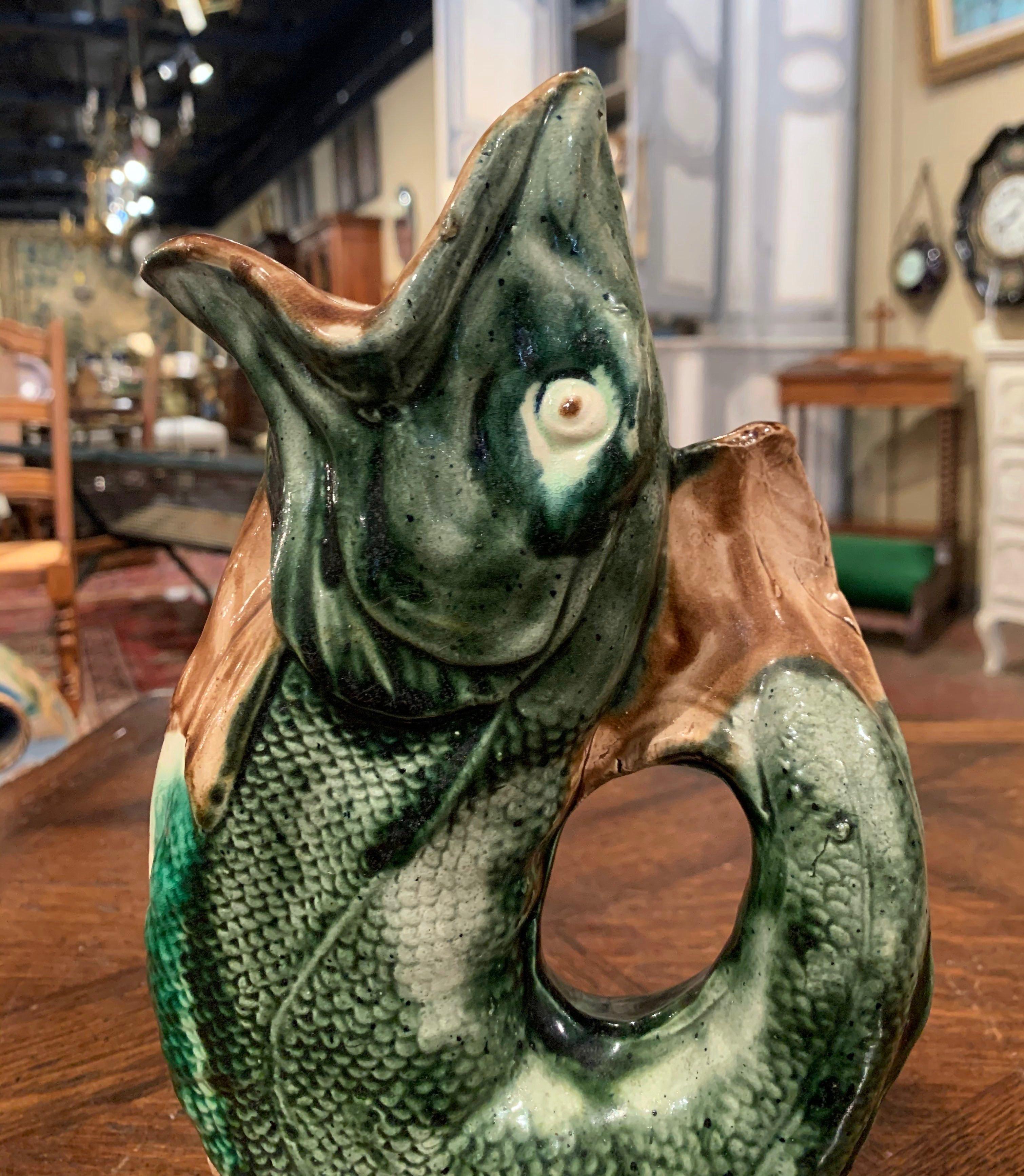 This lively pitcher would make an interesting addition to any porcelain collection. The colorful, antique water pitcher shows the beautiful artistry and painterly application of color true to Majolica ceramics. The porcelain vase was sculpted in