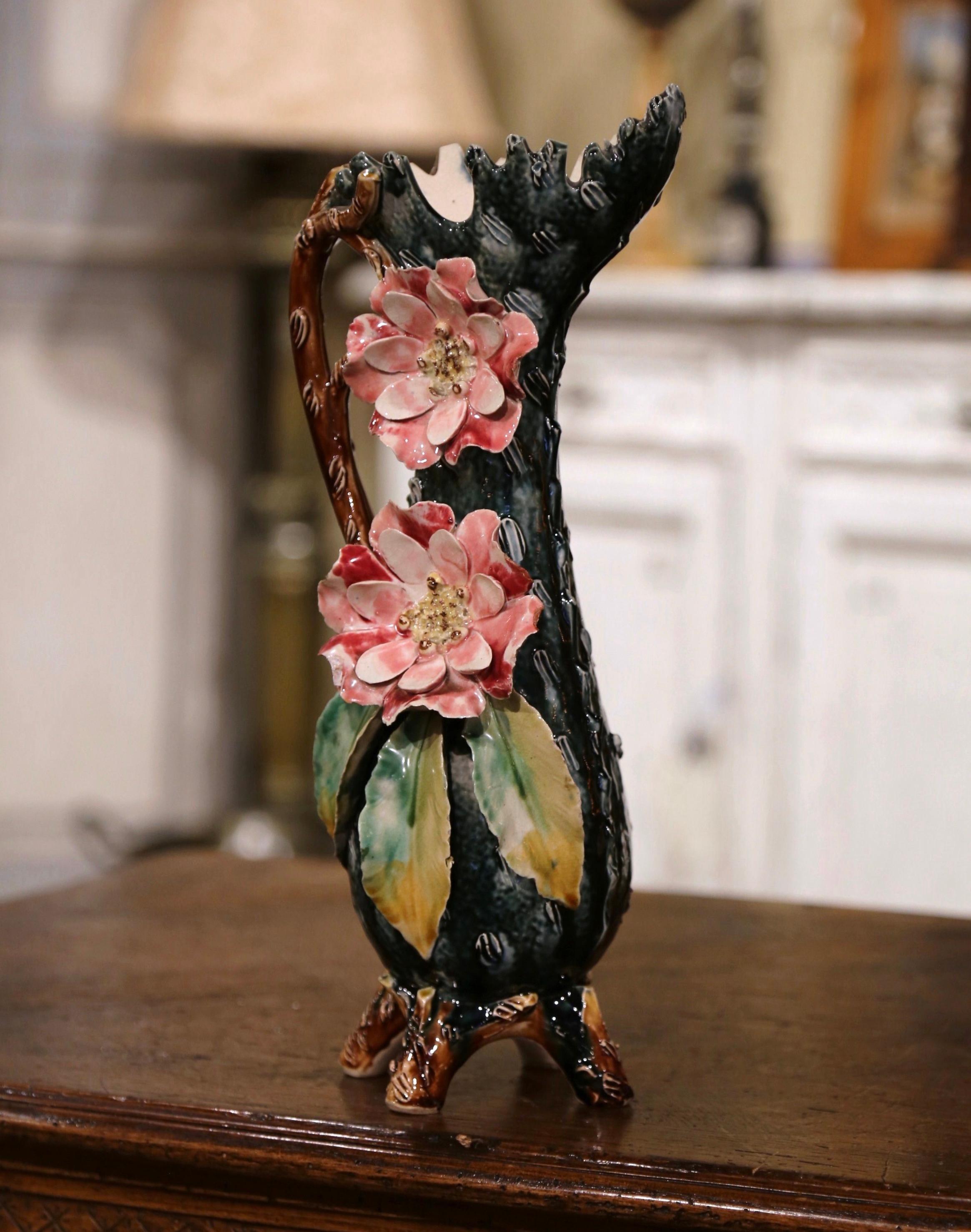 Beautifully sculpted and colorful, this antique Majolica vase would be a wonderful addition to a mantel, tabletop or bookshelf. Crafted in France, circa 1870, this hand-painted piece stands on four curved feet and features a wide and scalloped neck