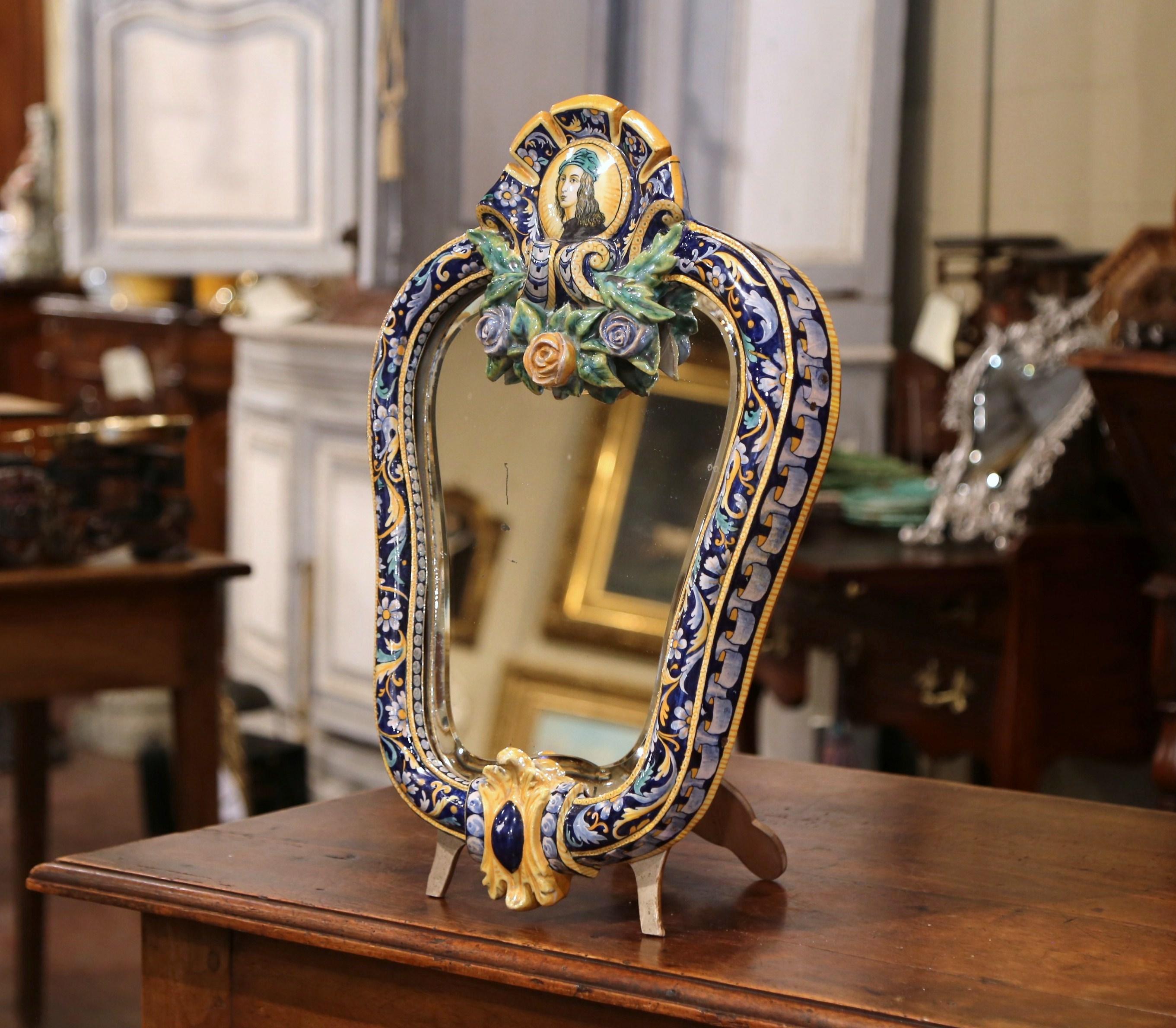 Decorate a counter with this elegant free-standing ceramic table mirror. Crafted in France circa 1860, the colorful, cartouche shaped mirror features a hand painted medallion with the profile of Joan of Arc, a pivotal character in French history.
