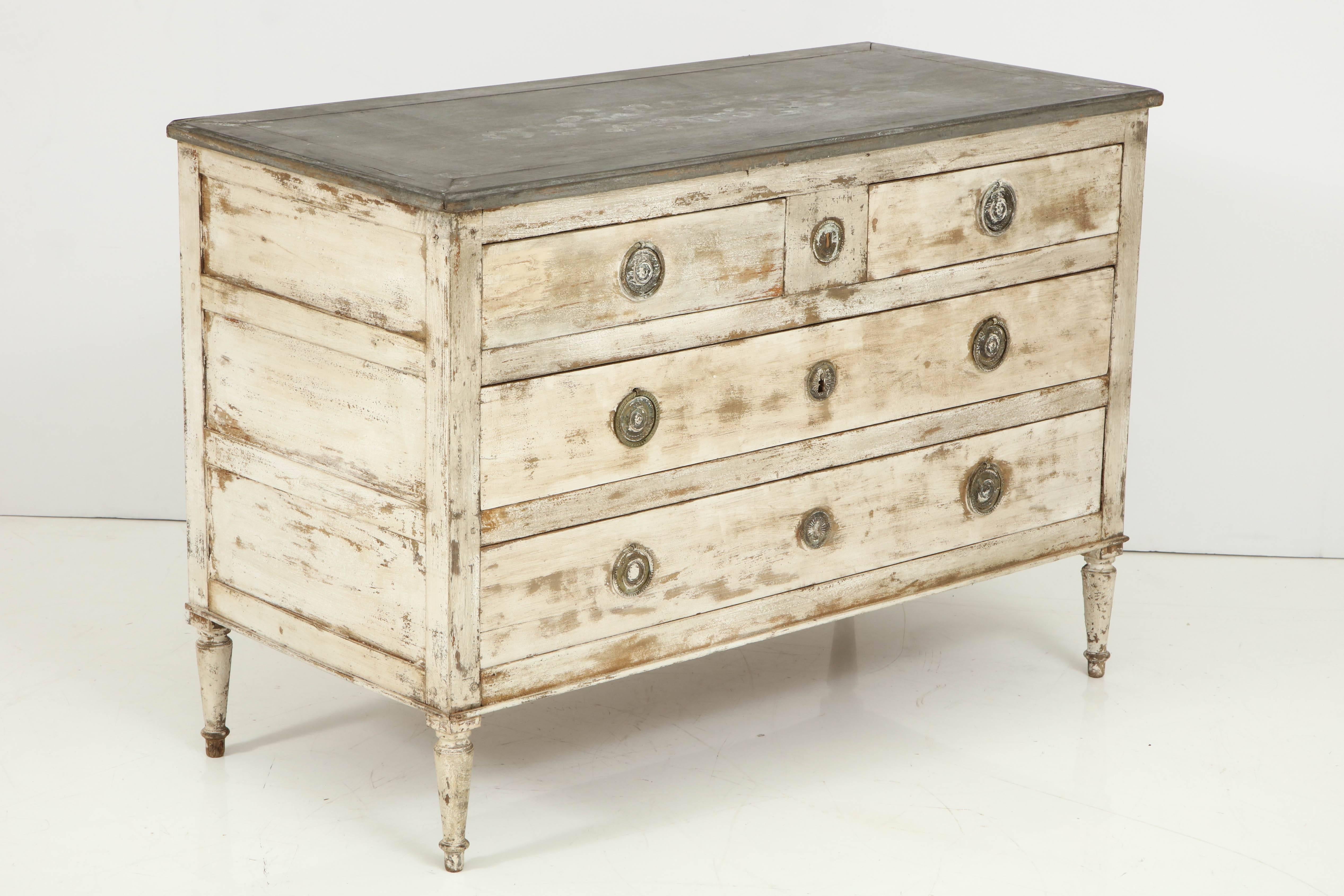 An early 19th century Directoire period chest with a lovely grayish white faded finish. The rectangular top is painted gray and surmounts two smaller top drawers and two larger lower drawers. The ring drawer pulls are in bronze and the chest is