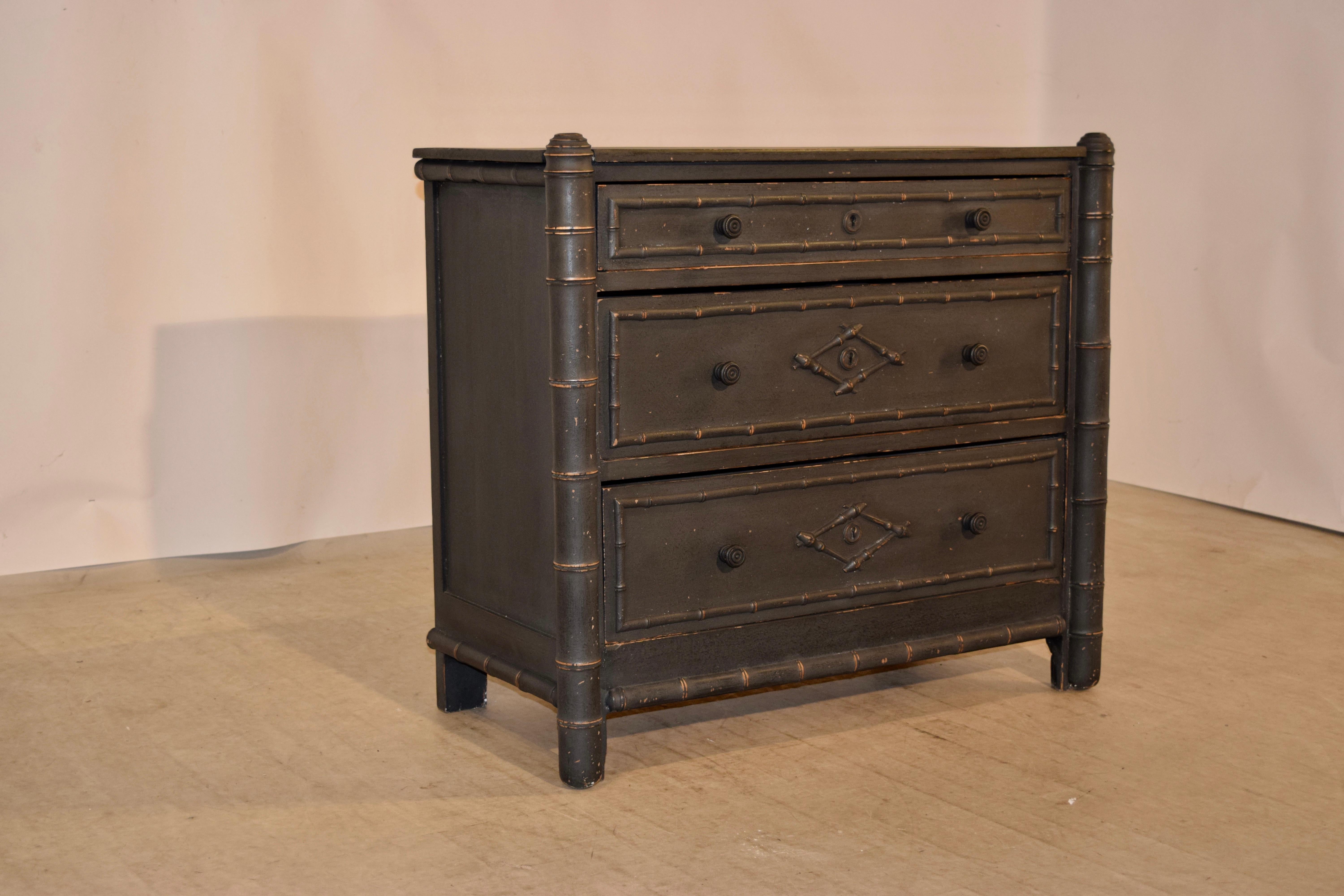 19th century chest of drawers from France with faux bamboo molding around the drawer fronts and case. The case has simple paneled sides and contains three drawers in the front, all with faux bamboo molded decoration and flanked by faux bamboo turned