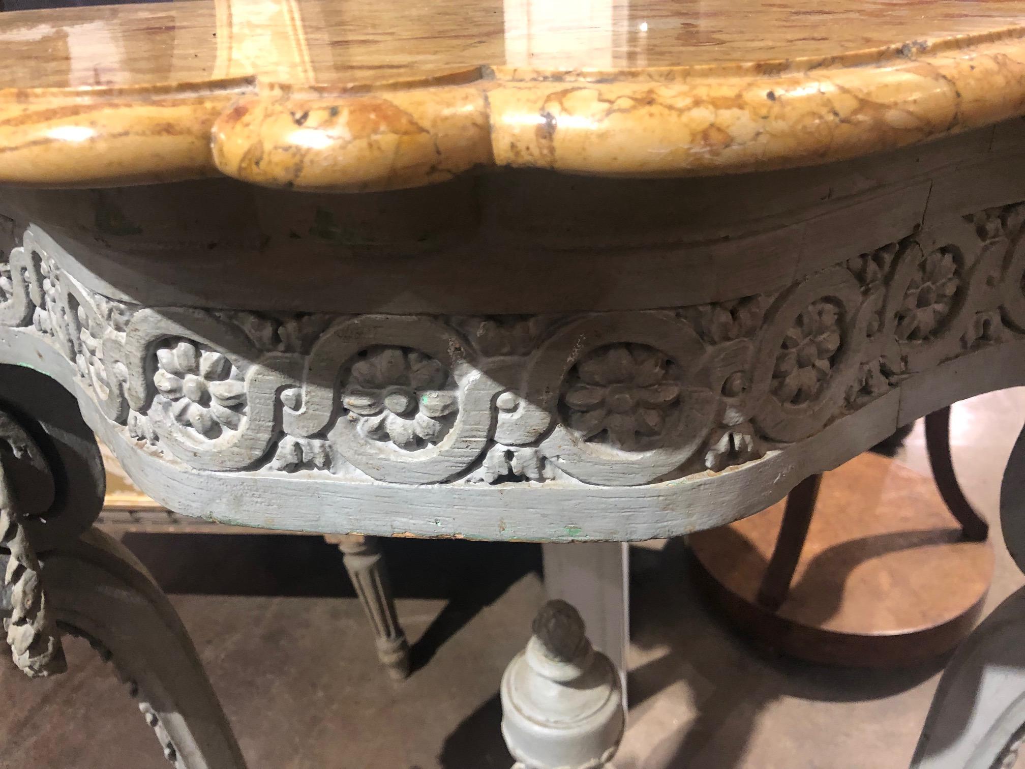 Splendid, 19th century French console table with superb quality shaped butterscotch marble top above a painted base with a carved rosette frieze. The entire on finely carved and contoured legs with festoon swags, shaped stretcher with urn and acorn