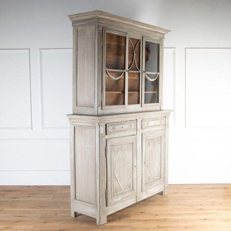 Armadio a vita alta francese dei primi del XIX secolo.
Questo bellissimo pezzo offre un ampio spazio di archiviazione e una forma insolita. La parte superiore è dotata di porte vetrate con motivi decorativi intagliati e di un interno non verniciato