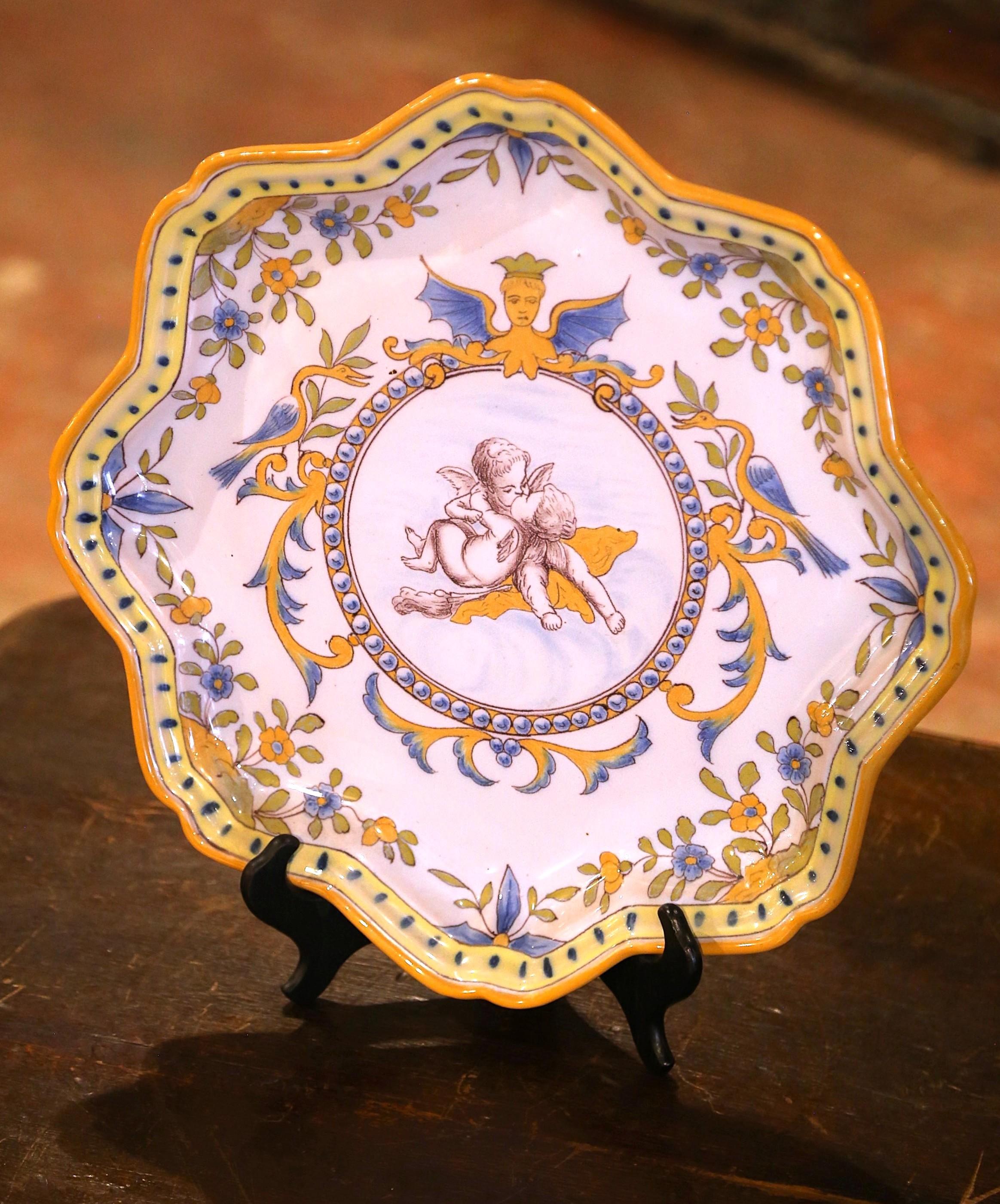 Decora una parete della cucina o una mensola con questo importante piatto antico. Creato dalla manifattura Charolles, in Borgogna, intorno al 1870, il grande piatto in ceramica dipinto a mano raffigura un medaglione centrale con due putti che si