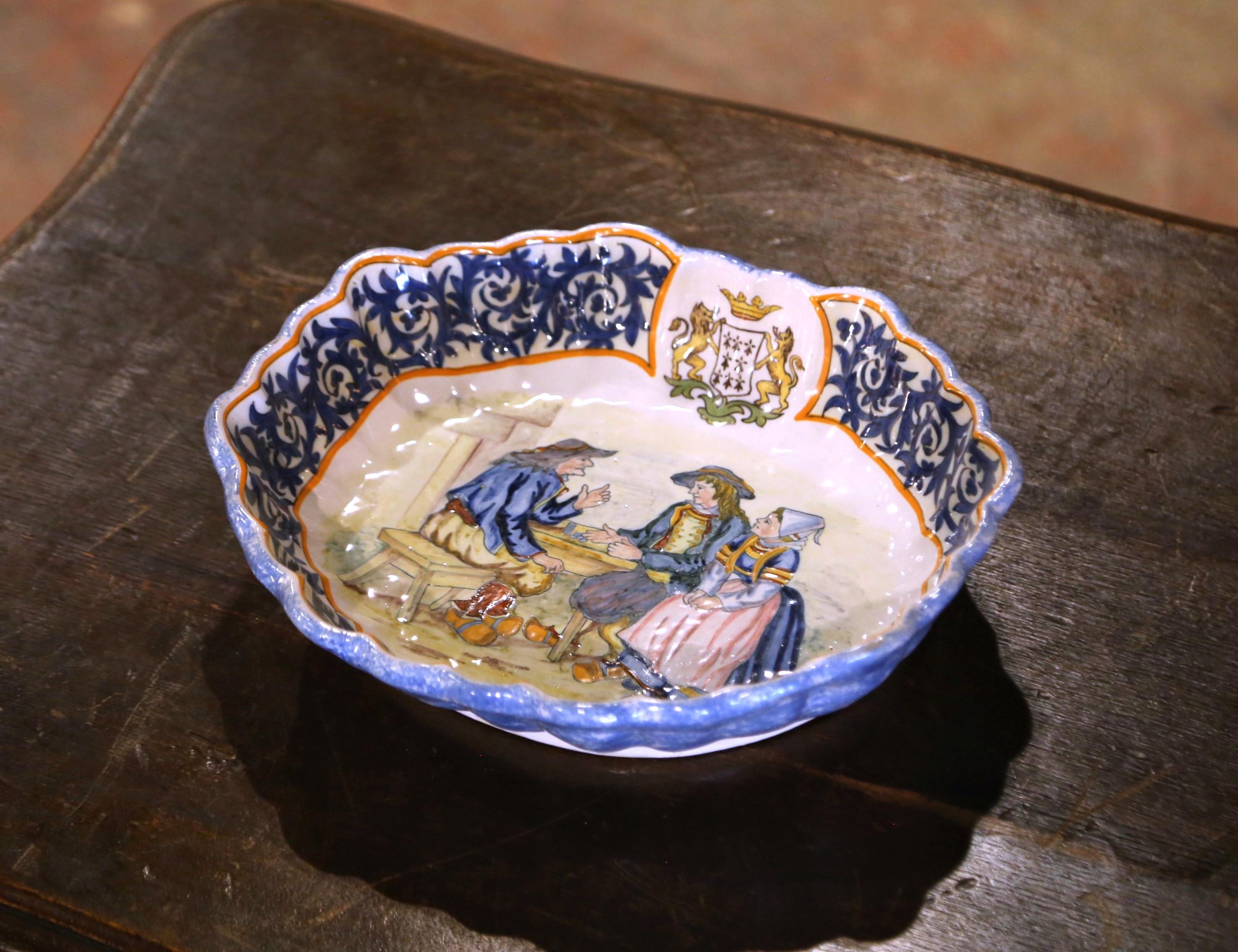 Decora una pared de la cocina o una estantería con este elegante cuenco antiguo. Creada por Porquier Beau en Quimper, Francia, hacia 1880, esta gran pieza de cerámica pintada a mano representa a dos hombres y una mujer sentados a una mesa con