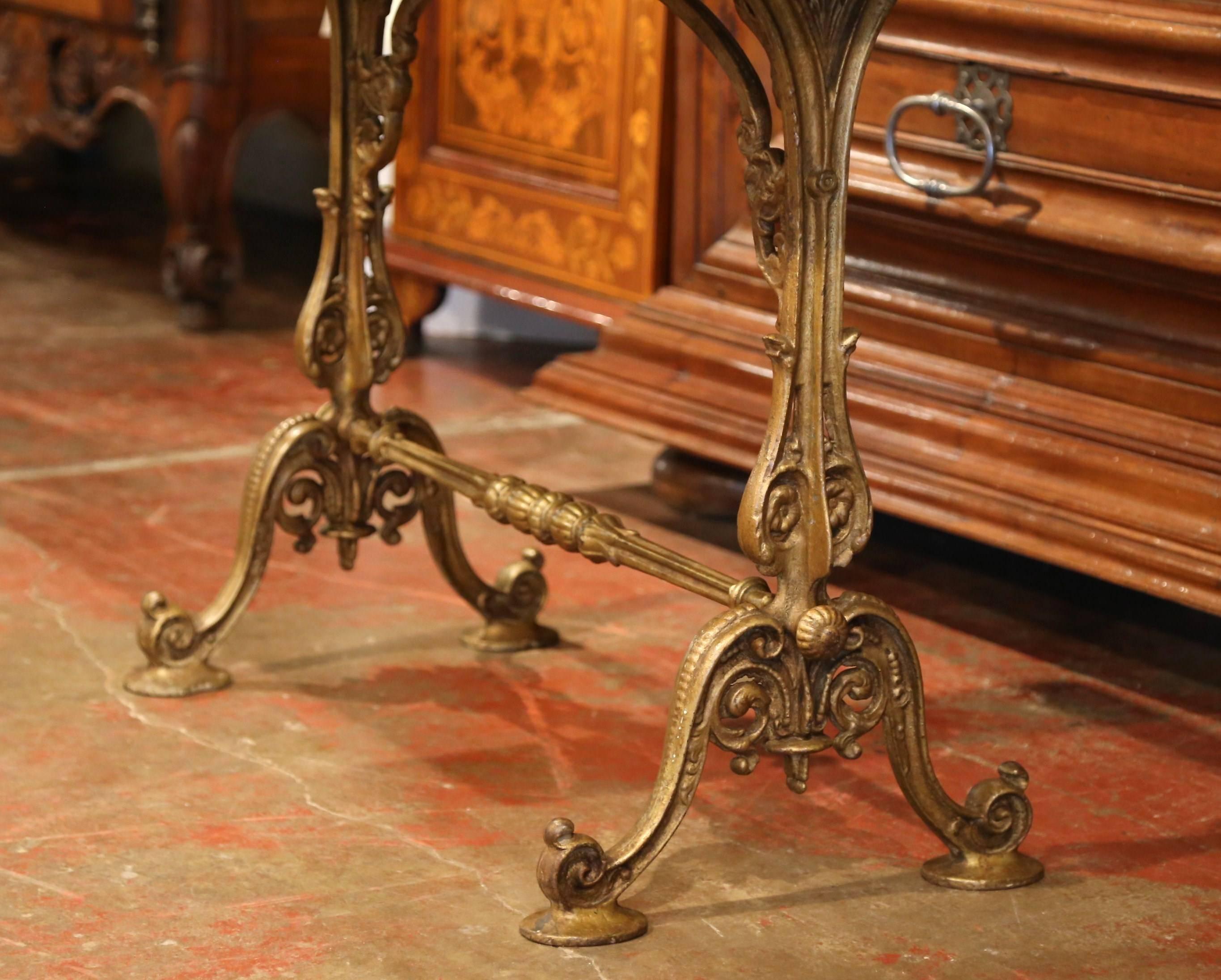 This elegant, antique bistrot table was forged in Paris, France, circa 1880. The versatile table could be placed outside or inside, and features two scrolled pedestals joined with a decorative stretcher and foliage. The piece has an aged white and