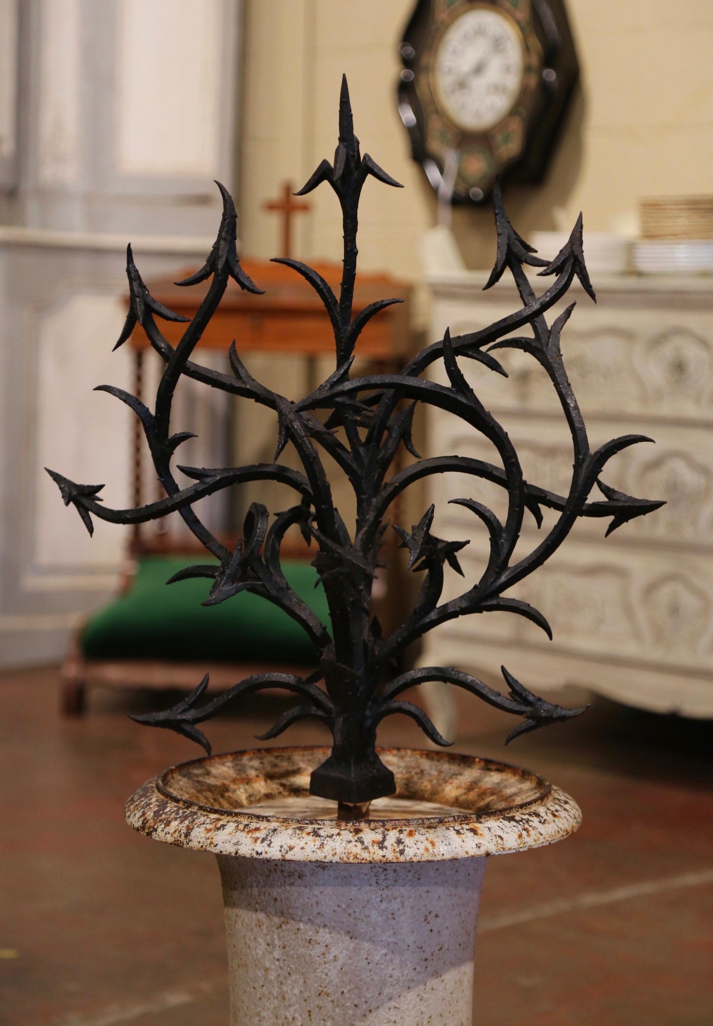 This antique urn composition was created in France circa 1880; made of iron, the medicis vase is filled with a tree like forged iron bush. The tall planter is in excellent condition with the original patinated painted finish, and could be used
