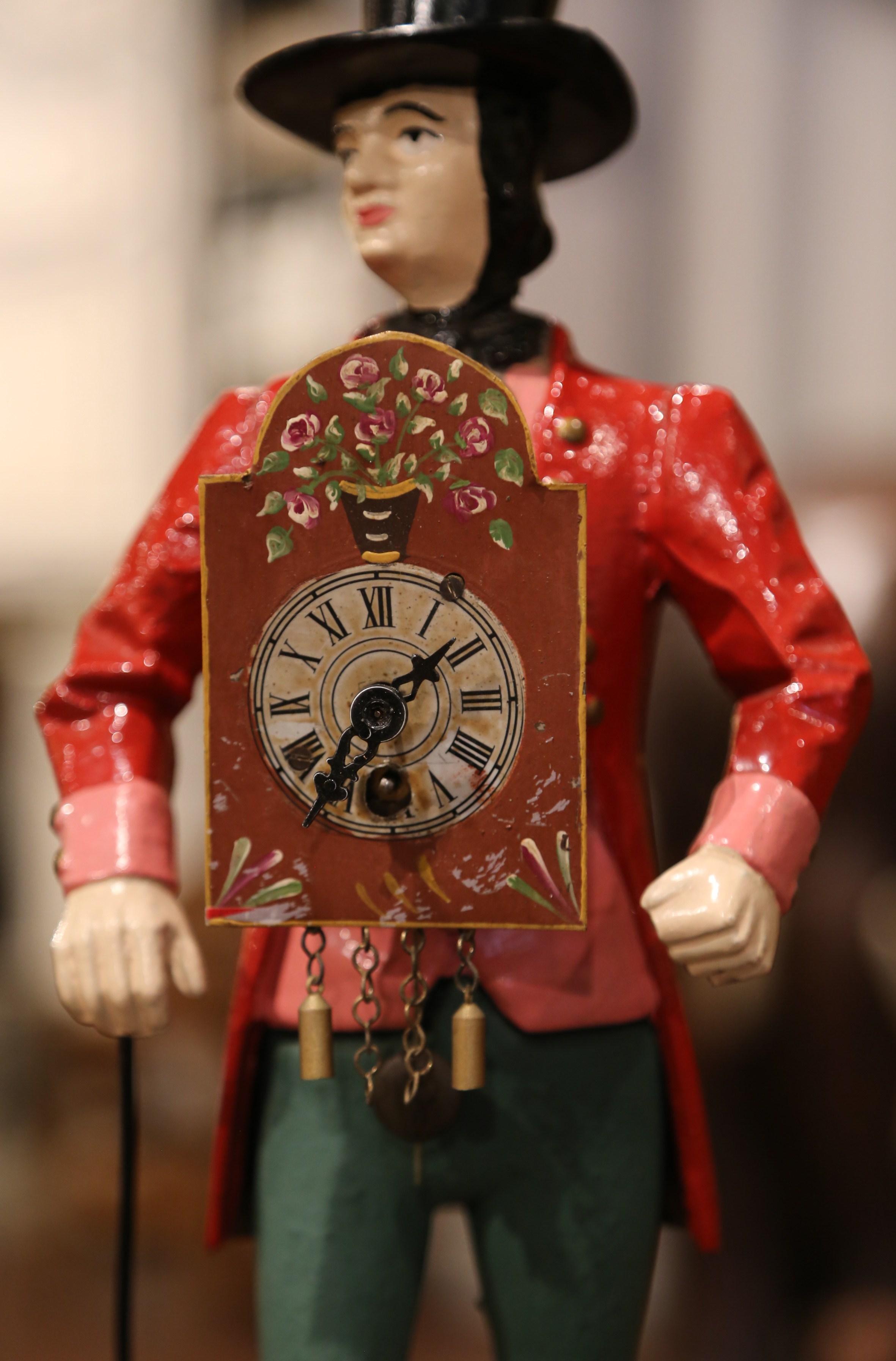 Place this colorful clock on a kitchen counter or a mantel. Crafted in France, circa 1880, the piece stands on a black metal base and depicts a clock salesman in formal clothing carrying a clock on his belly. The original clock mechanism has been