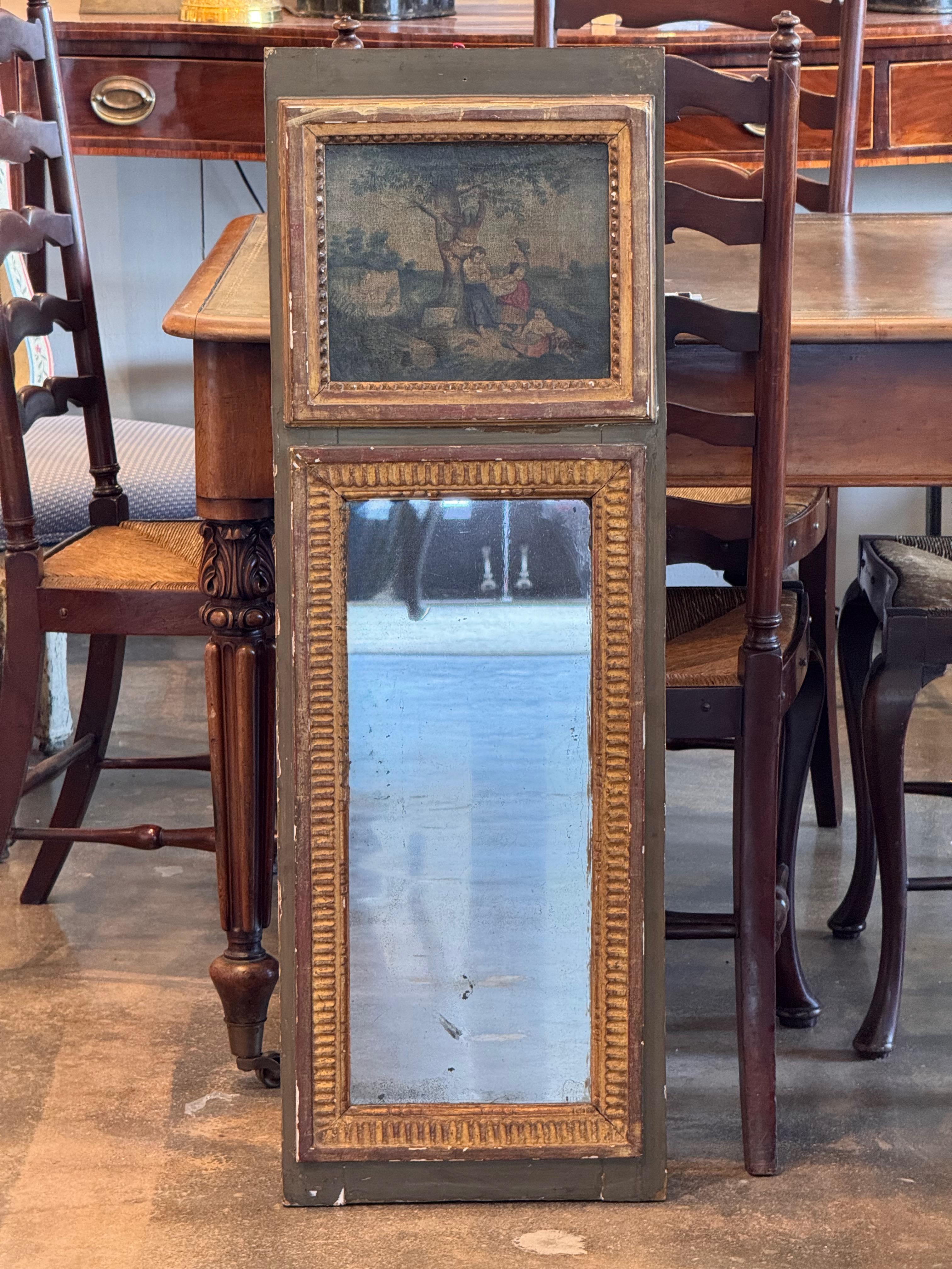 Un charmant miroir peint français du 19e siècle présentant un design unique en deux parties. Le panneau supérieur présente une scène pastorale sur toile, encadrée d'une élégante bordure sculptée et dorée, tandis que la partie inférieure abrite un