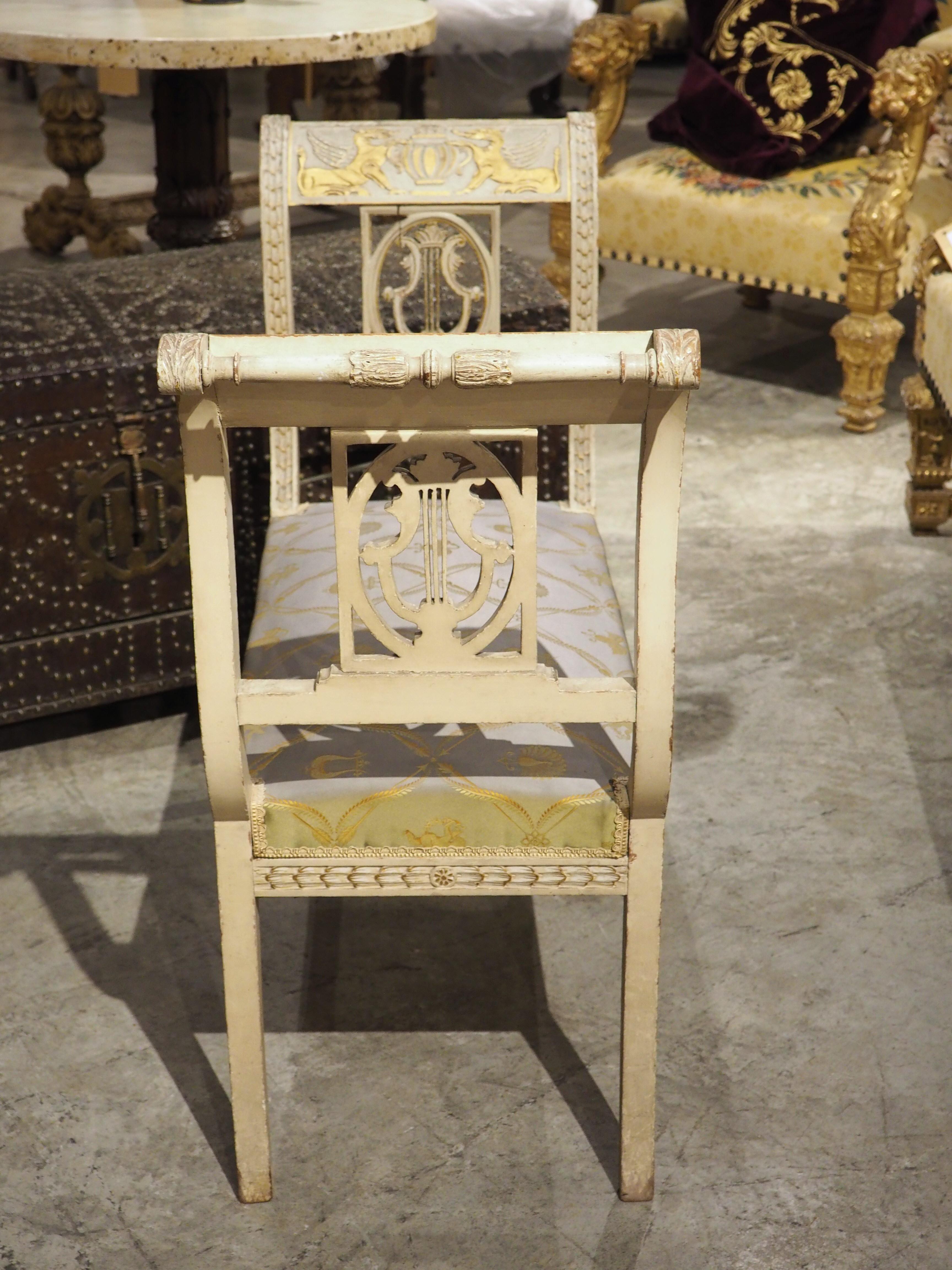 Designed to be lightweight and transportable, a banquette is a small backless bench, often upholstered with fine fabrics, such as silk or velvet. This hand-carved and hand-painted French banquette from the 1800s is in the Neoclassical style, with
