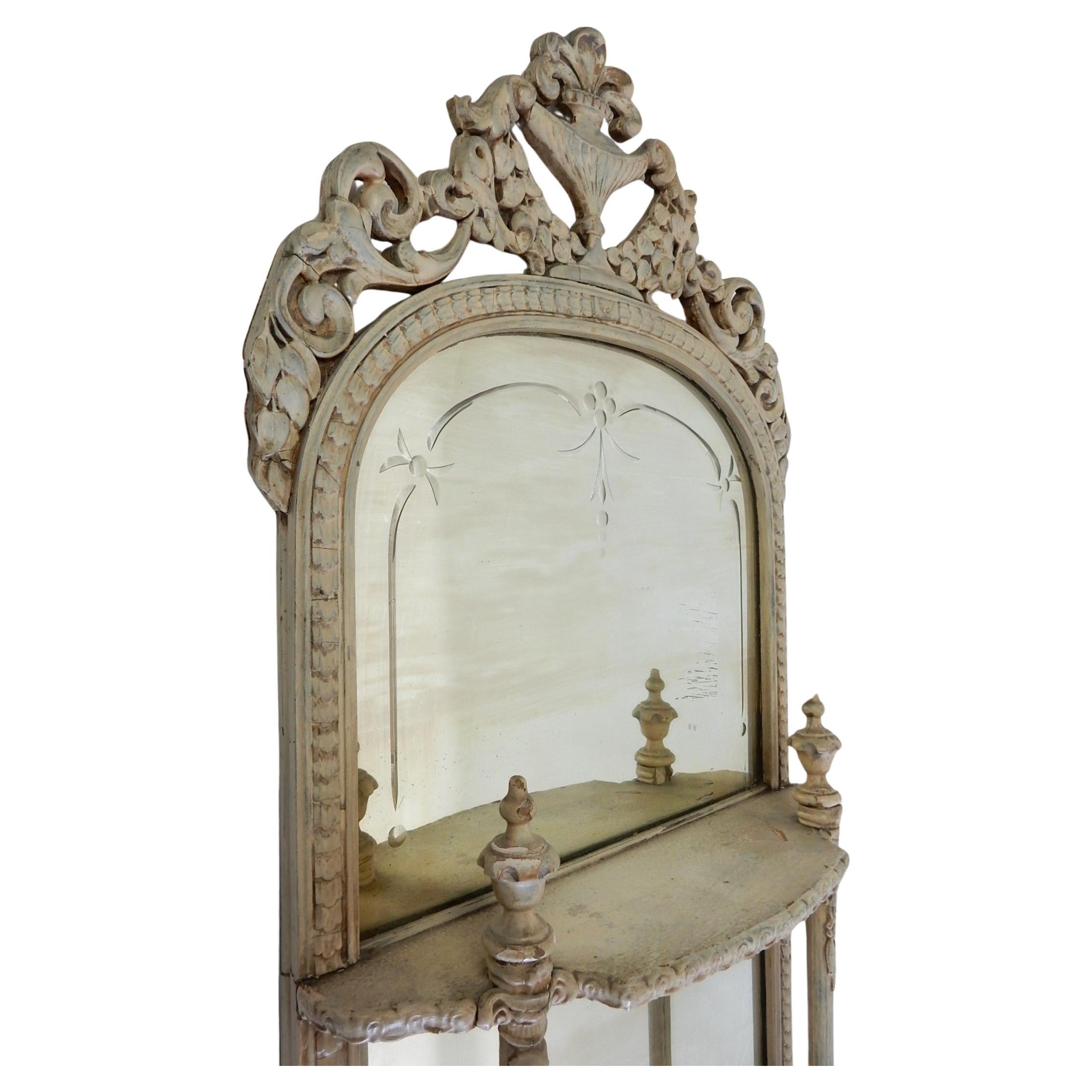 Fabuleux miroir mural provençal orné de fleurs. 
3 étagères pour les parfums et les objets de curiosité. Il mesure 1,5 mètre de haut.
Recouvert d'un émail de couleur ivoire crémeux.
Beaucoup de patine d'ancienneté sur la peinture et la surface