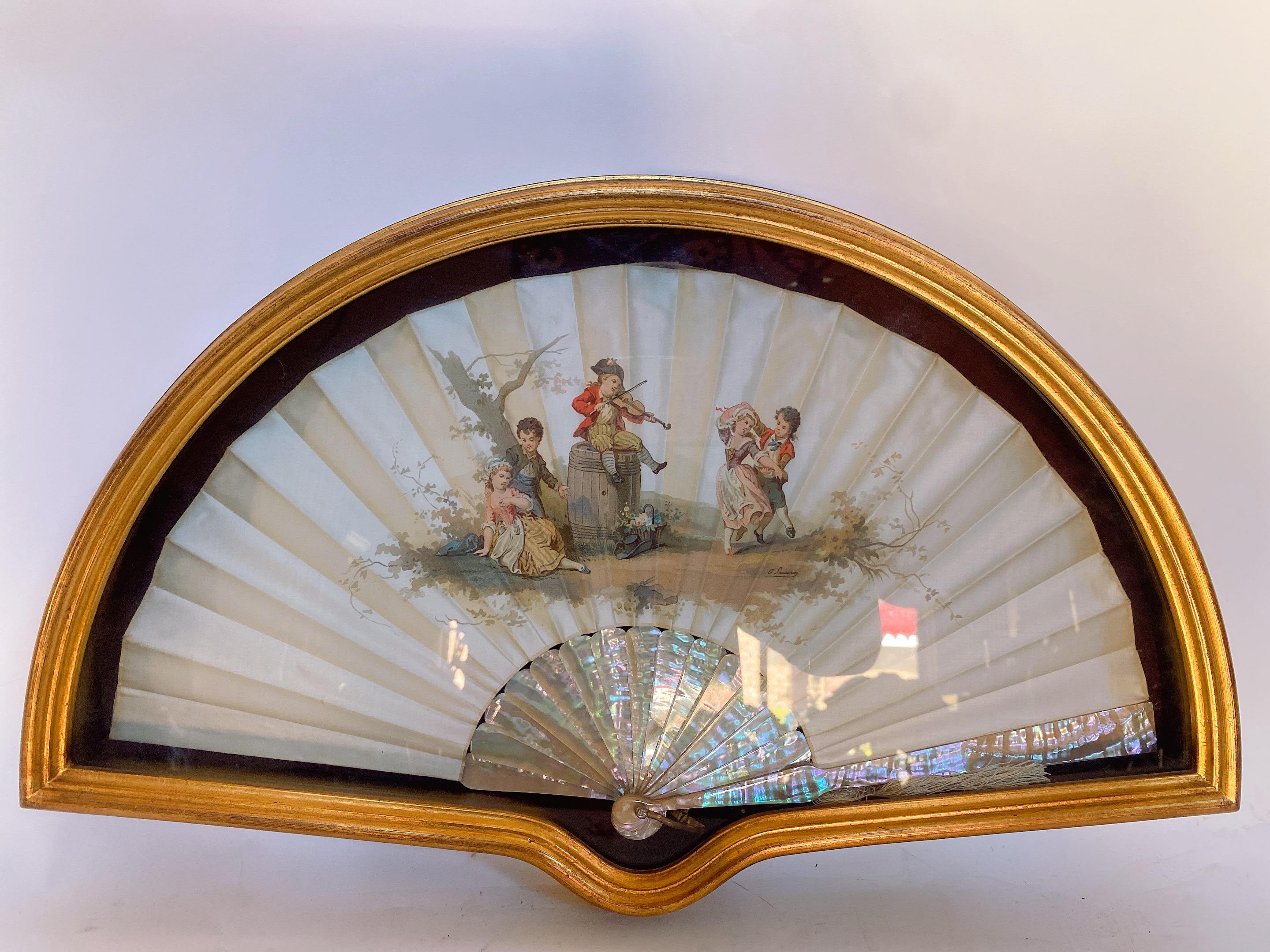19th Century French painted silk of mother of pearl fan, shadow-box framed antique ladies fan, made of mother of pearl with gold leaf on the outer edge. The mother of pearl sticks have etched brass inlaid into them in the shapes of flowers. Overall