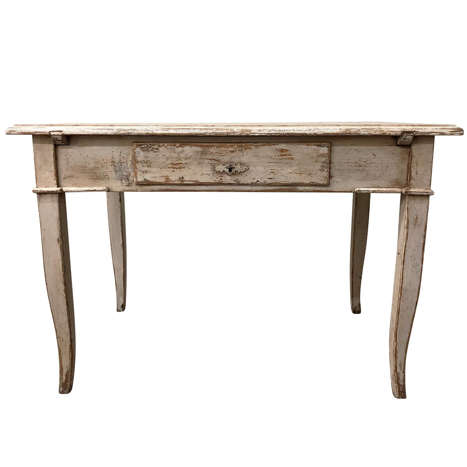 An antique French farmer’s table made of hand carved walnut, original hardware with one-drawer with a white washed finish, supported by four slightly wooden curved legs. The end table represents the French Provincial period. Wear consistent with age