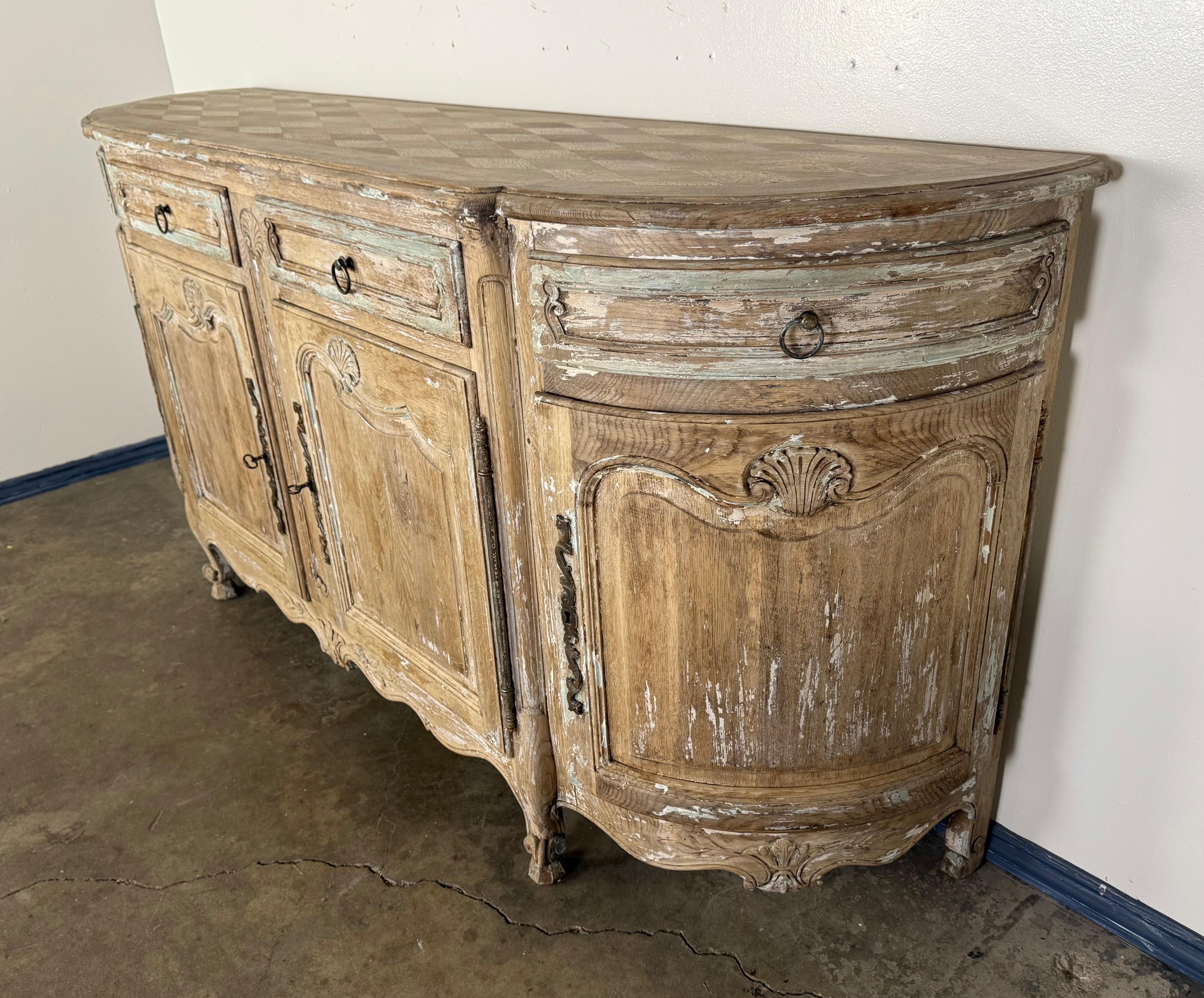 Es handelt sich um ein französisches Sideboard im Louis-XV-Stil aus dem 19. Jahrhundert mit einer anmutig geschwungenen Front und geschwungenen Seitenwänden. Das aus Eichenholz gefertigte Möbelstück weist an den Türen und Schubladenfronten