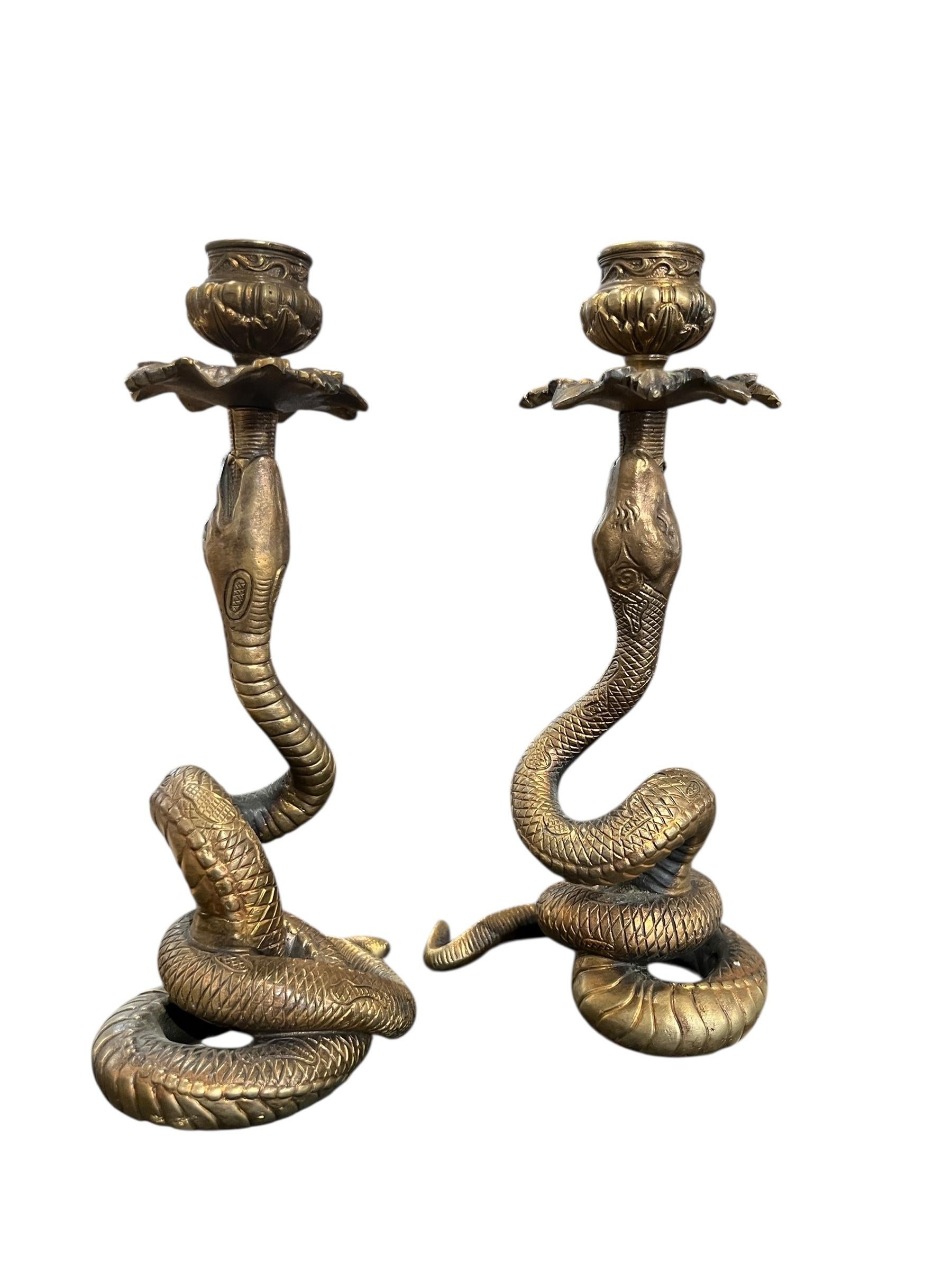 Une captivante paire de chandeliers en bronze ancien sculptés en forme de serpent. Leurs corps sinueux s'enroulent vers le haut pour tenir les bougies, mêlant des détails naturalistes à une touche de mysticisme et de symbolisme classique.