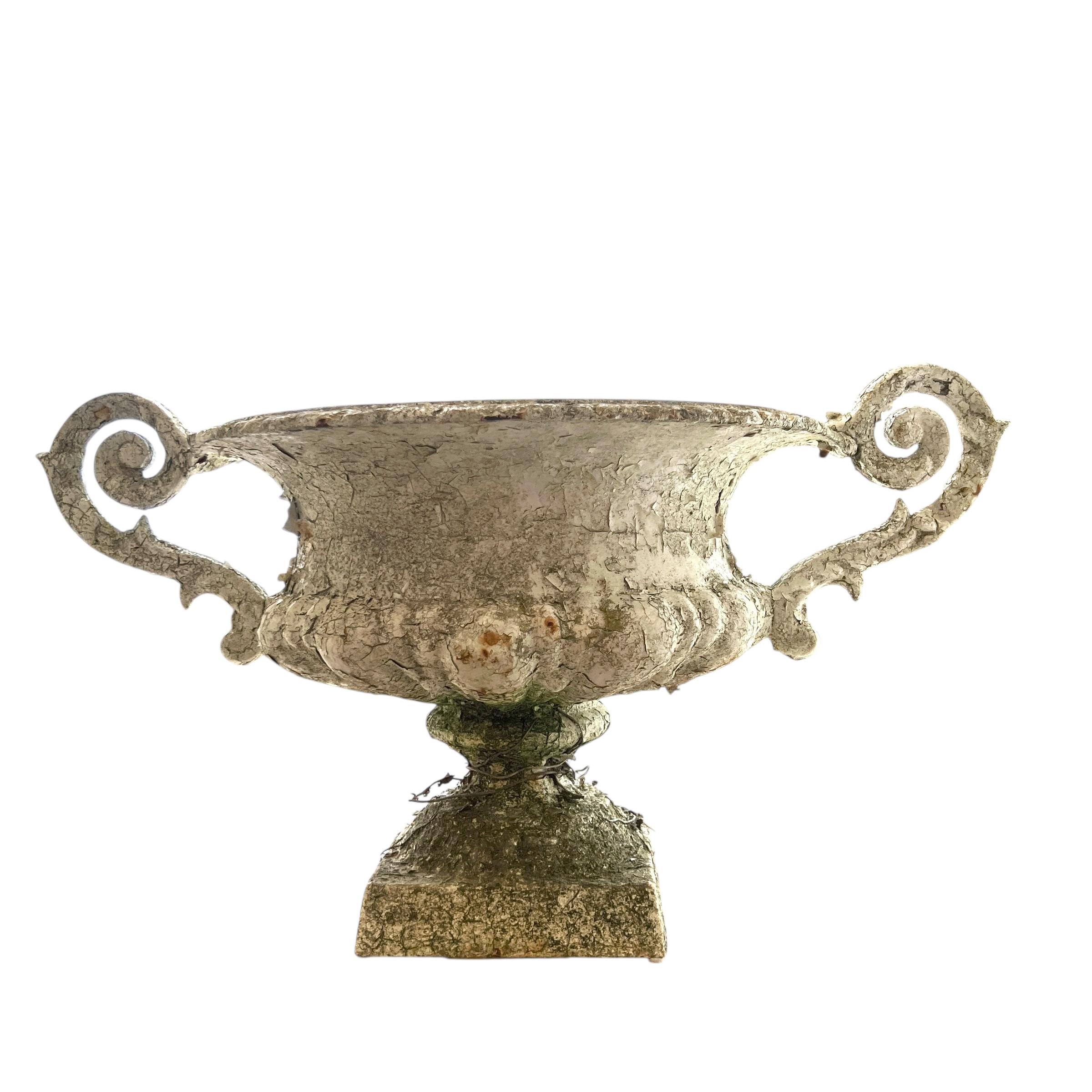 A pair of 19th century French iron jardinieres with richly patinated surfaces and decorative pierced motifs, showcasing elegant scrollwork and timeless garden sophistication rooted in classical French design.