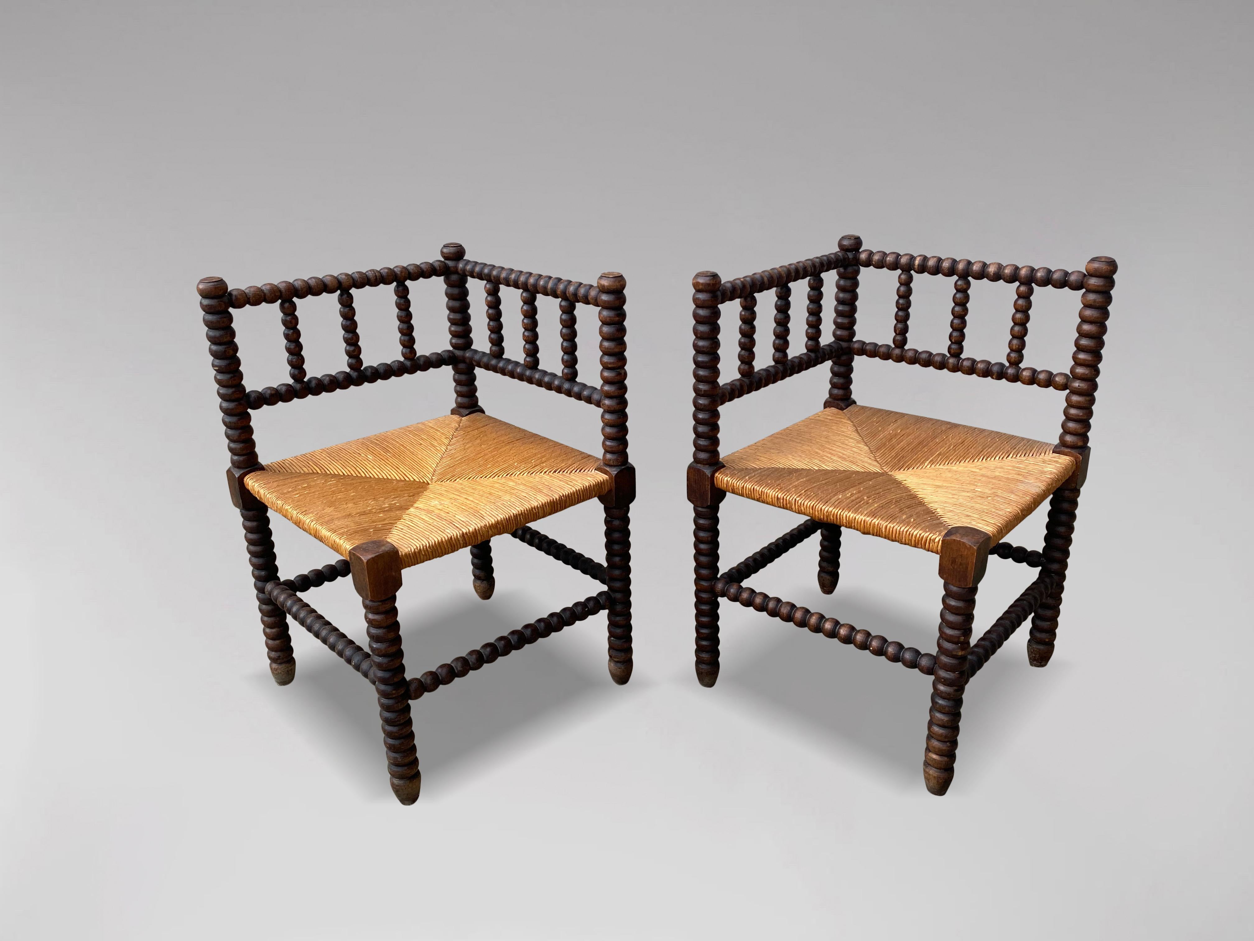 A charming pair of late 19th century French provincial bobbin wood corner chairs. Beautifully turned oak frames with the original striped rush seats. Sourced from the south of France and in very good antique condition. Seat height is 37cm.

The