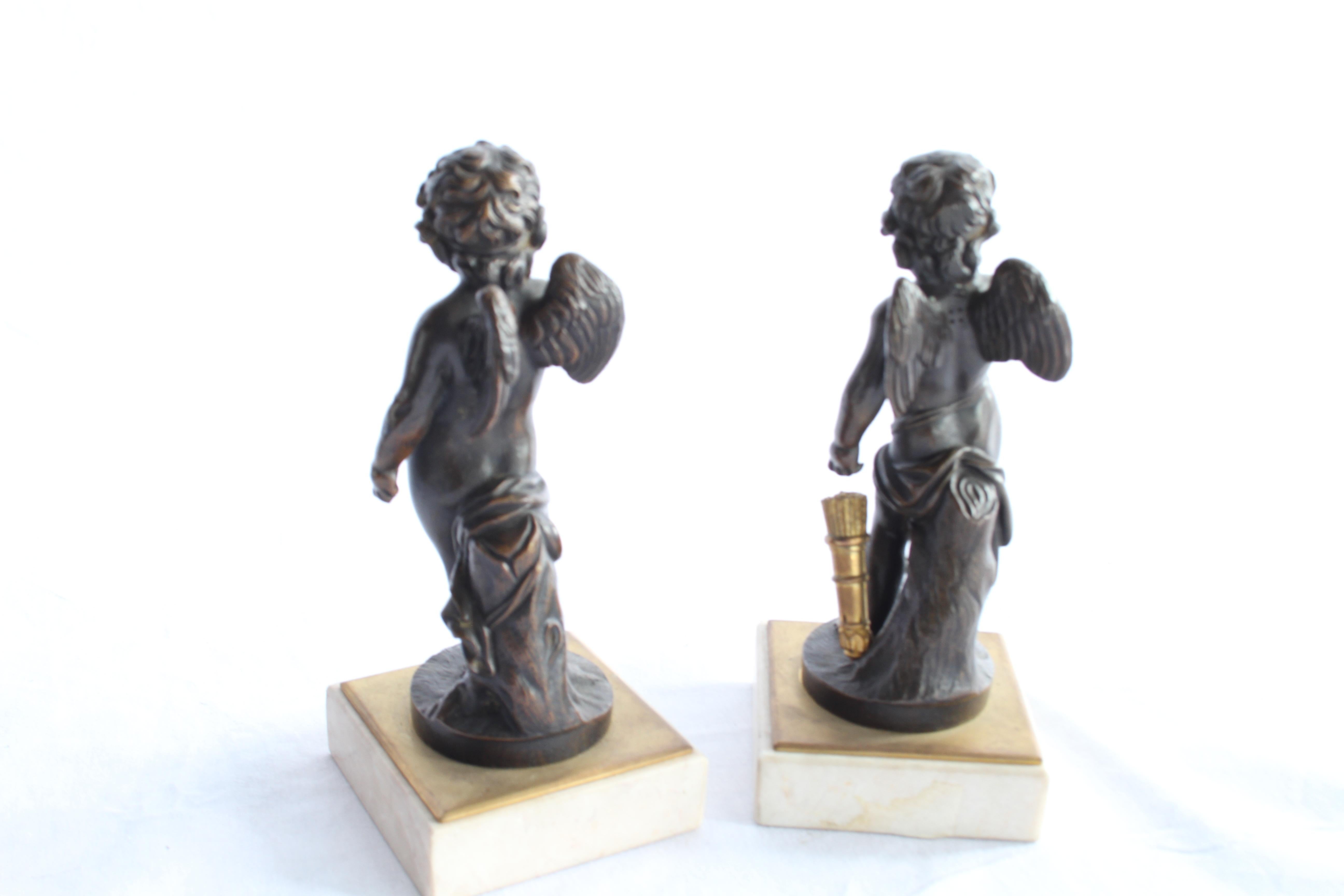A pair of French bronze figures of winged cherubs. French first half of the 19th century. Dark brown patination. Each supported on a white marble base of square section.