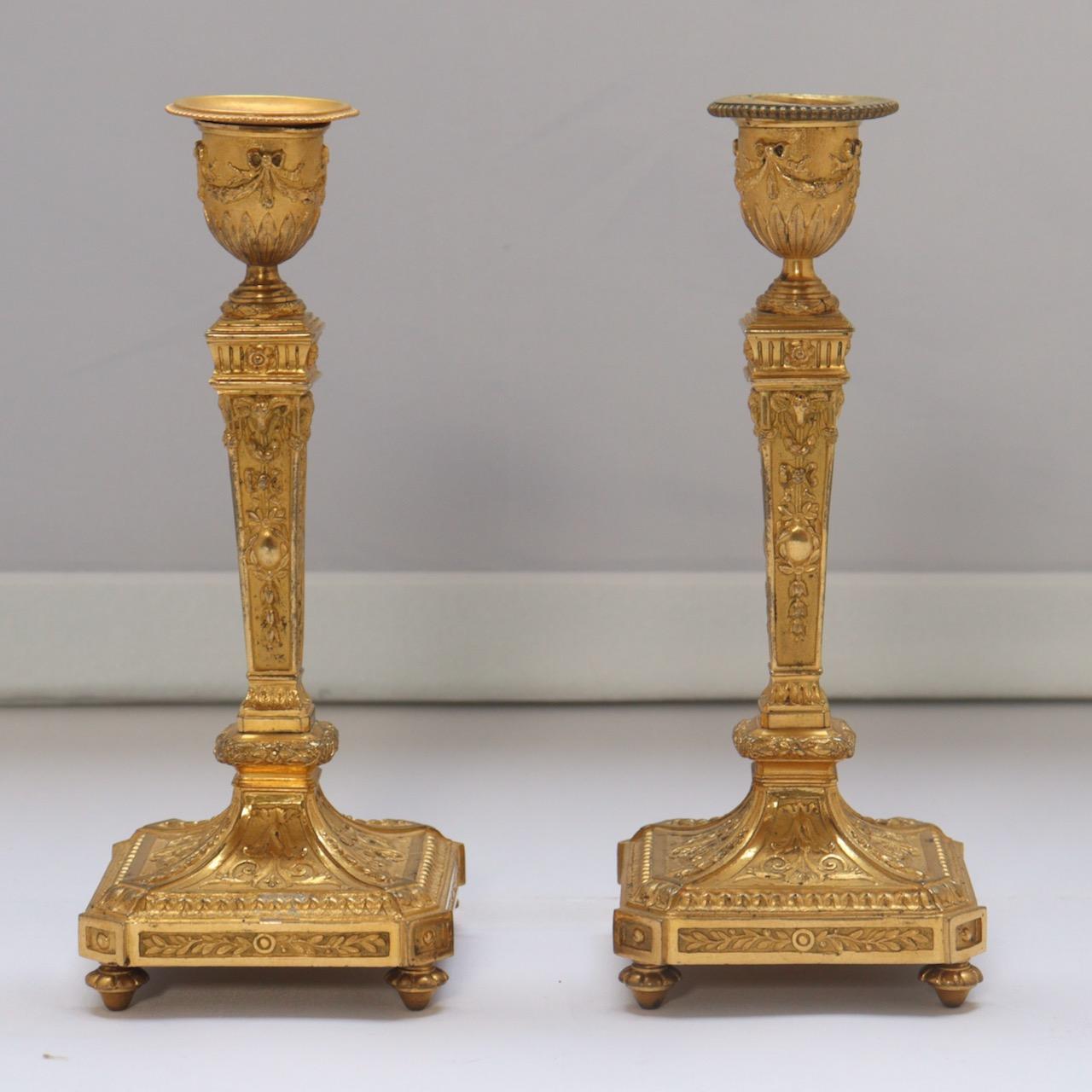 French 19th century pair of candelsticks 

In ormolu, very finely chiseled and decorated with knotted garlands, branches of leafy flowers, spokes of hearts, leaves of water, pearls. The was in sheath resting on a square base with curved 
doucine