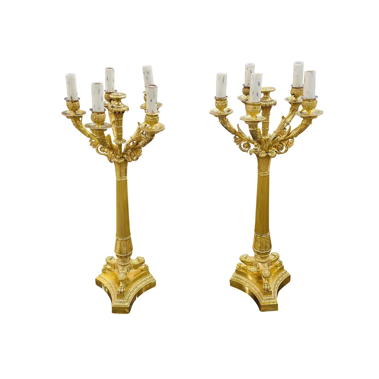 Antiguo par de candelabros franceses Charles X, de bronce dorado, hechos a mano, en buen estado. Cada uno de los detallados candelabros se compone de cinco palos de vela que se detienen en cortos brazos curvados, sostenidos por un afilado tallo