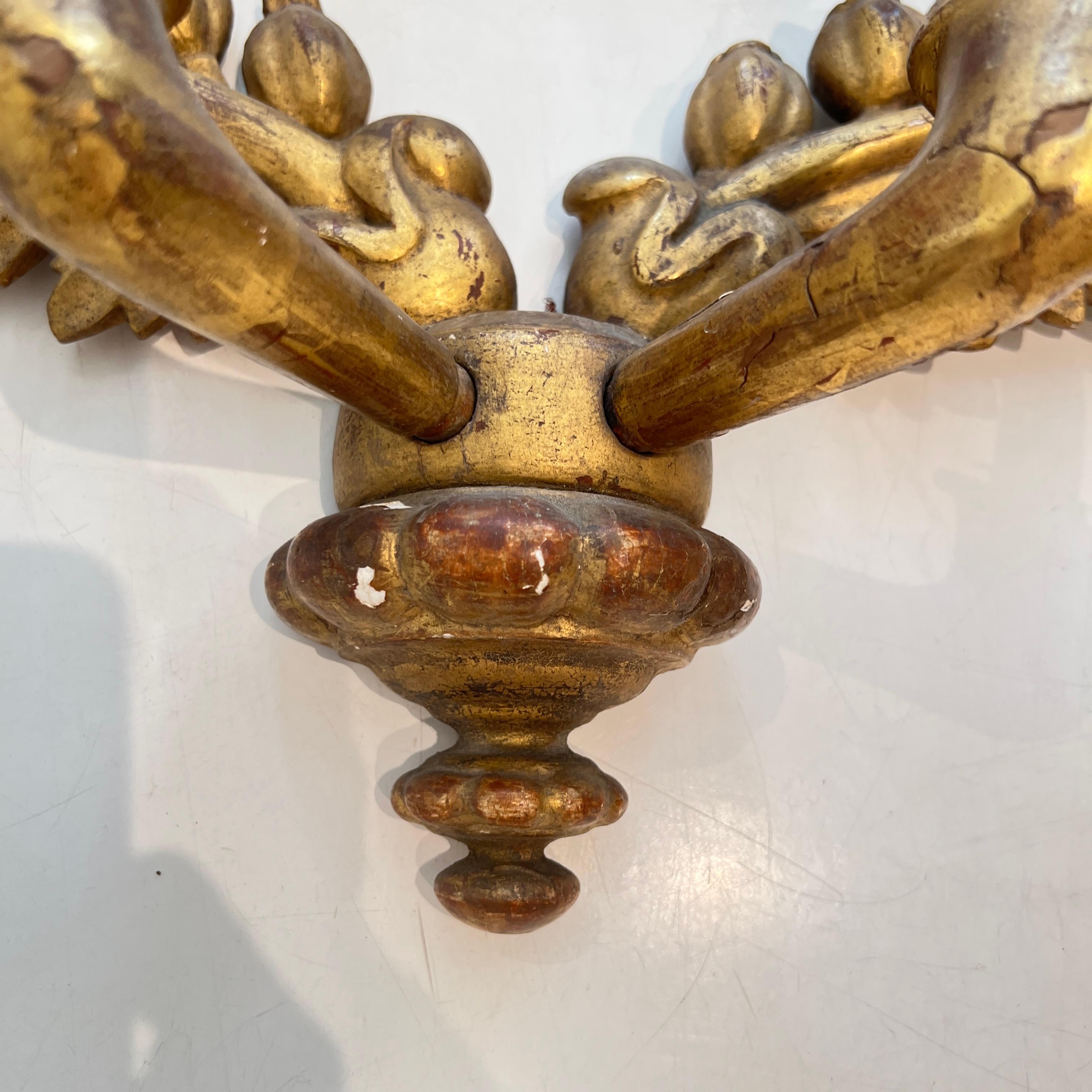 Ein raffiniertes Paar vergoldeter Charles-X-Holzleuchten mit klassischen Motiven, sanft geschwungenen Armen und reichem Blattgold-Finish, die den Übergang des frühen 19. Jahrhunderts in Frankreich zu zurückhaltender Eleganz mit königlicher Präsenz