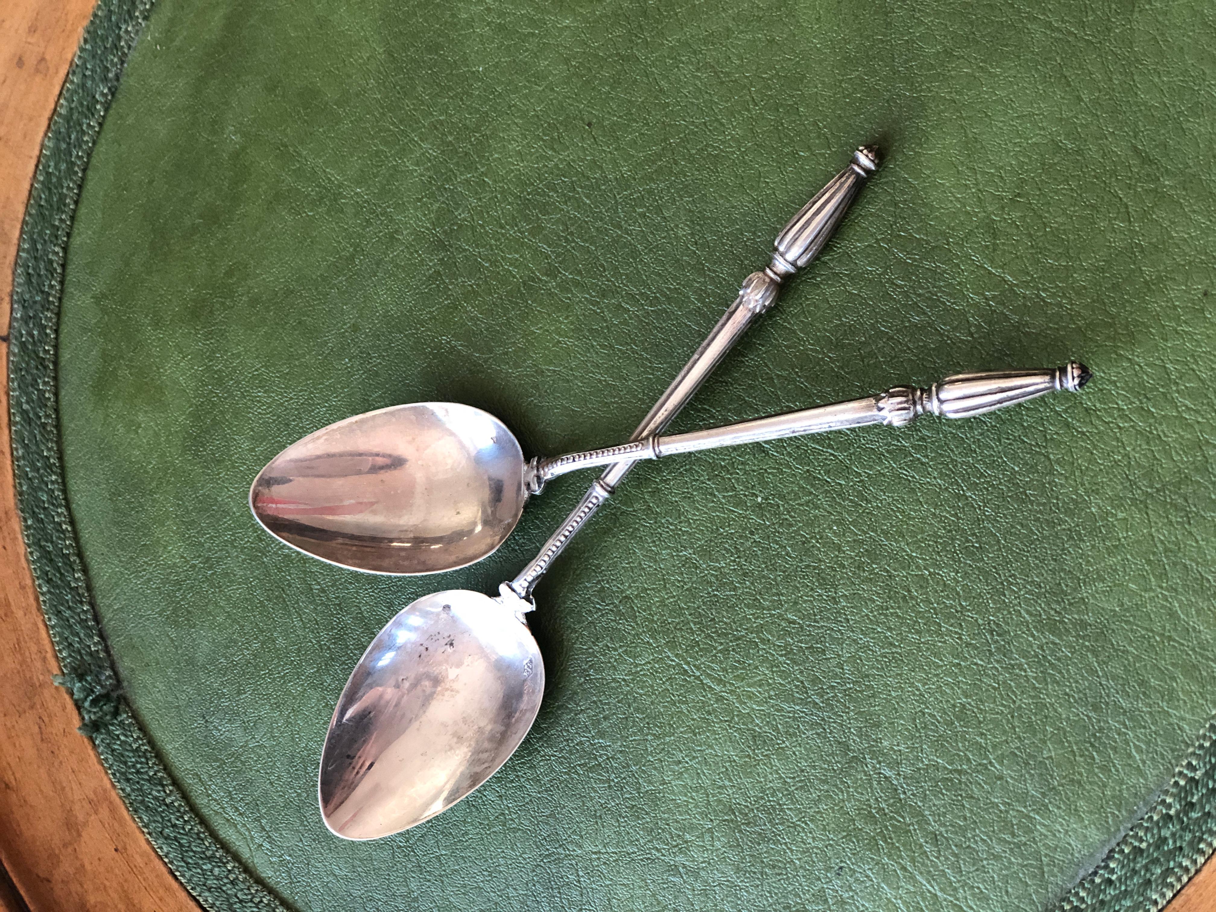 A pair of truly exceptional for the richness of the decoration sterling silver dessert spoons, stamped 