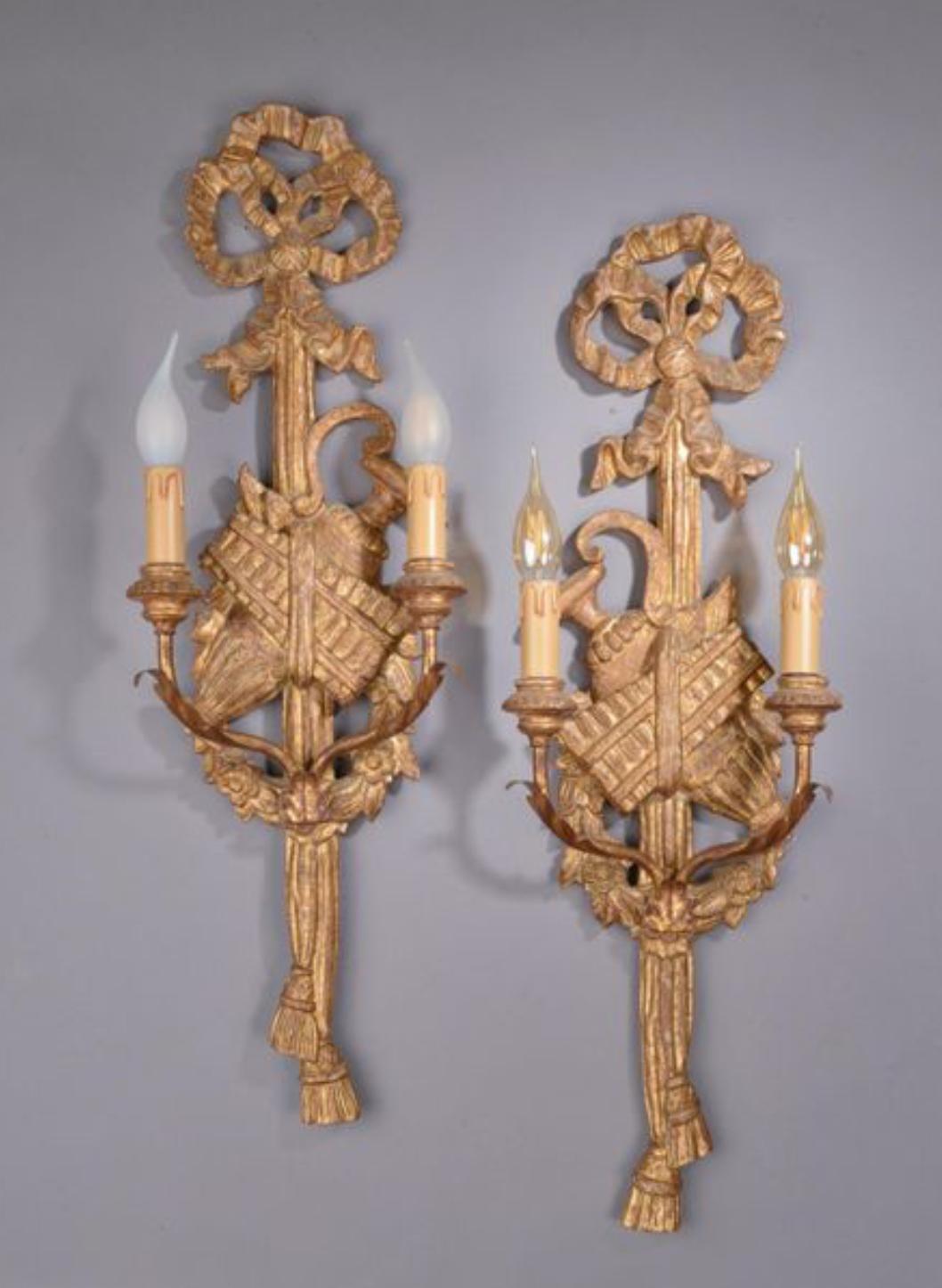 Ces appliques françaises anciennes de style Louis XVI, sculptées à la main et en bois doré, sont réglées et câblées pour deux ampoules chacune.
France, vers 1880.