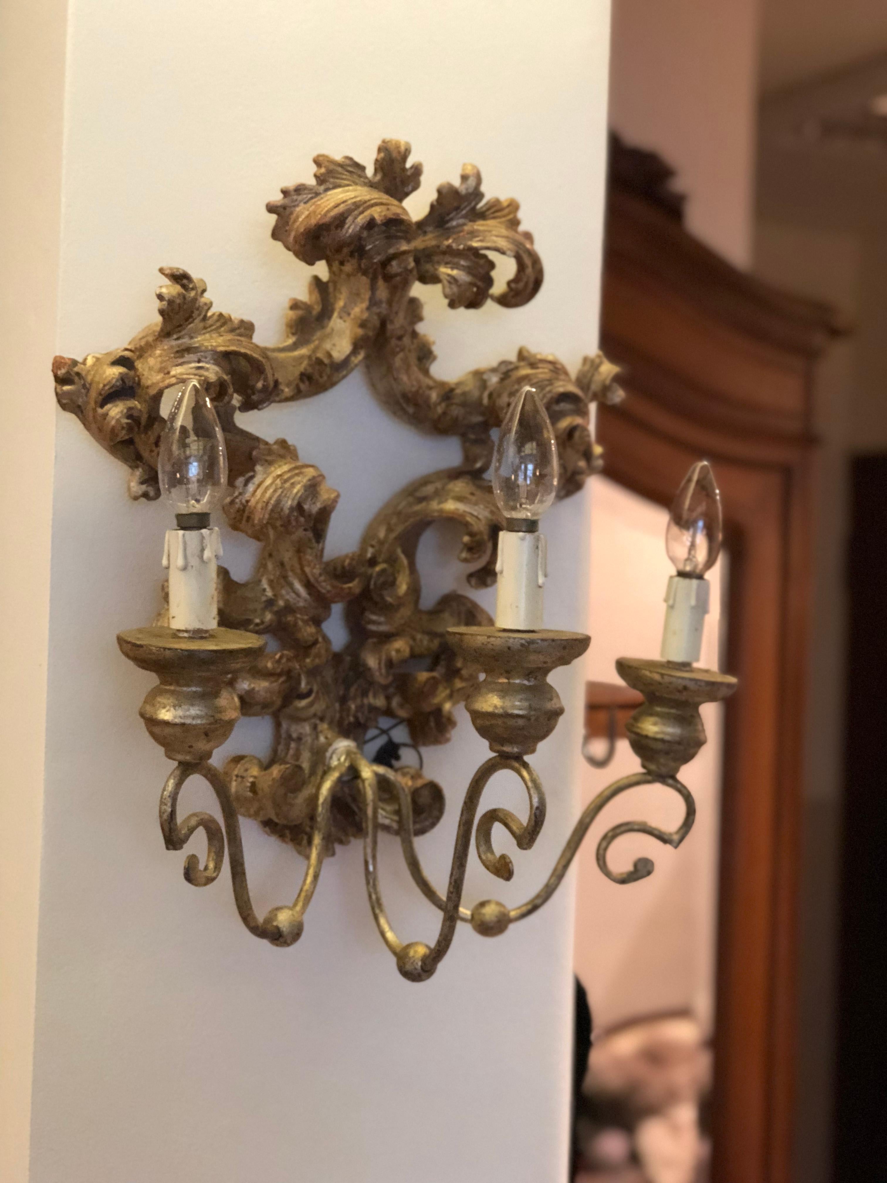 These antique Baroque style hand carved giltwood sconces have wrought iron armatures wired electrically for bulbs with rich leaves decoration.
France, circa 1880.