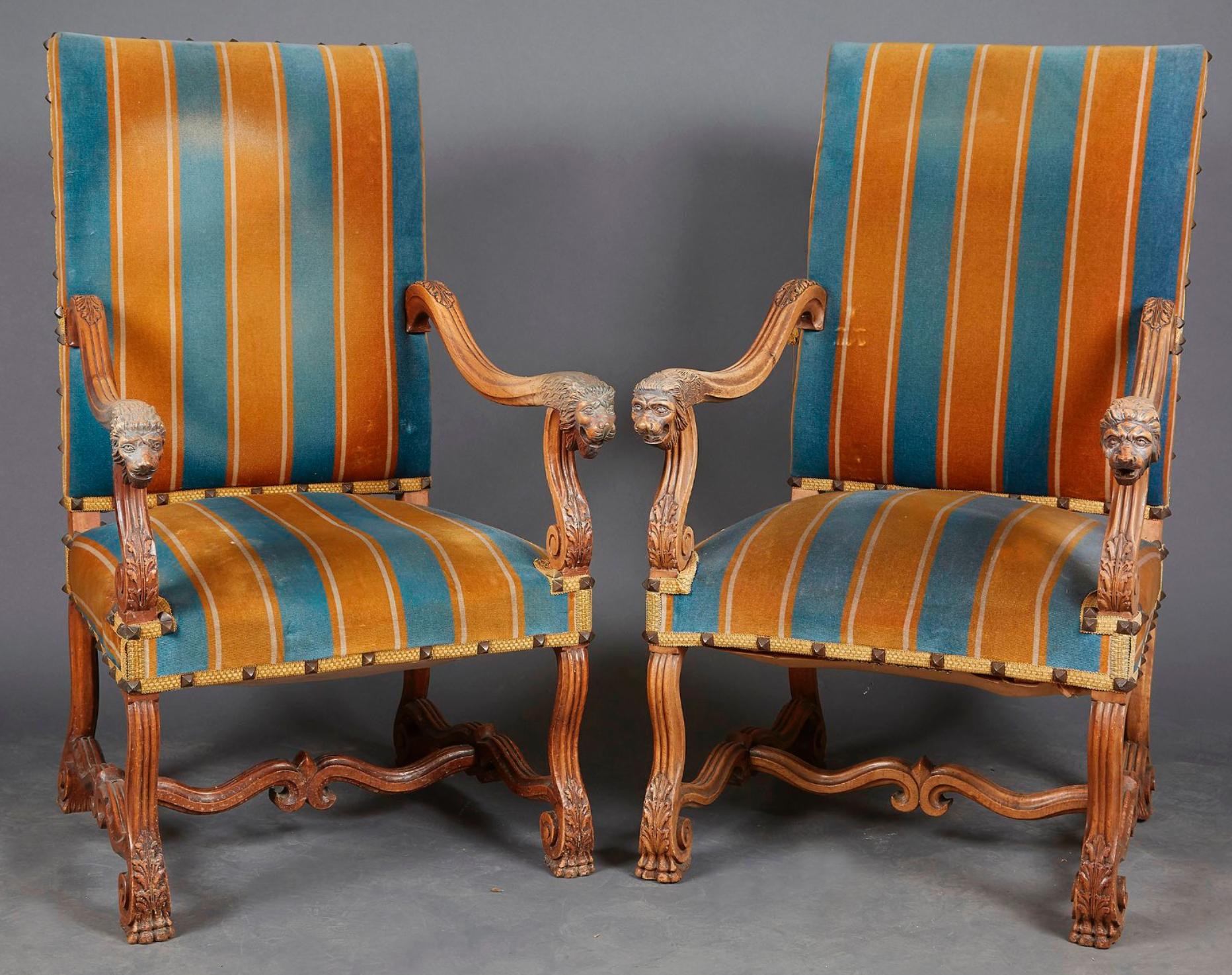 19th century French pair of large hand-carved armchairs made of oak decorated with lion heads e feet, with velvet upholstery.
France, circa 1870.